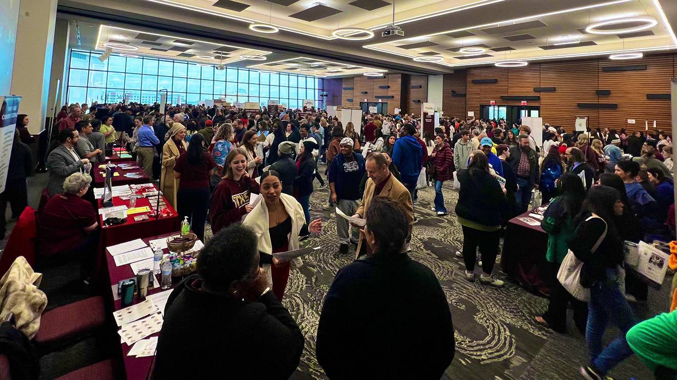 A large crowd of students, staff, and faculty fill the LBJ Student Center Grand Ballroom, seeking information about TXST during Bobcat Day.