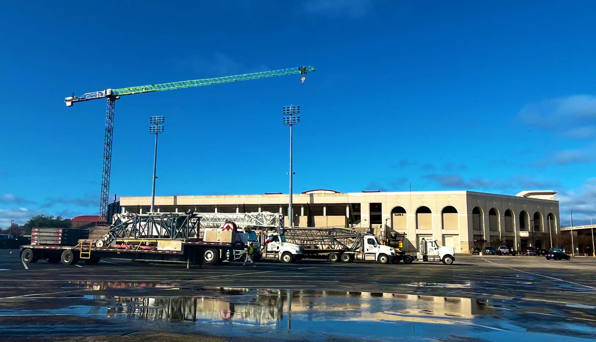 A crane rises above Bobcat Stadium during a sunny day.