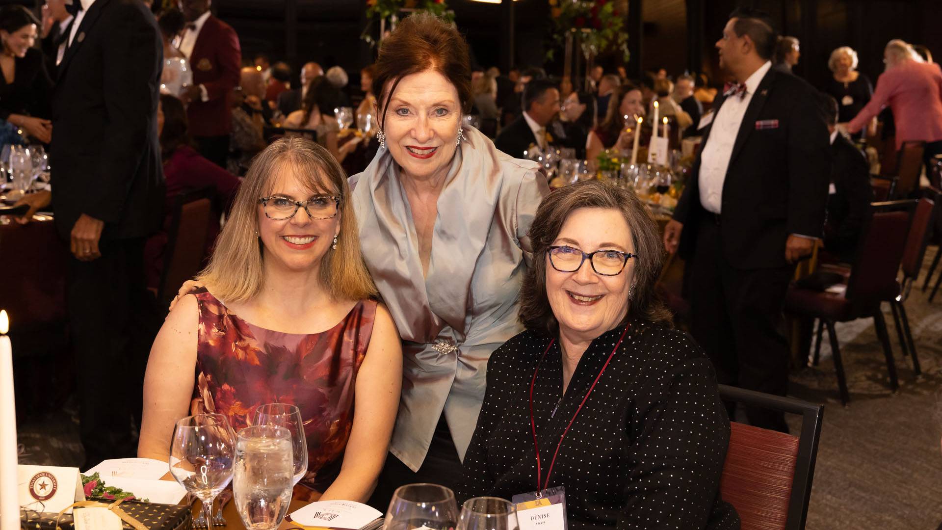 Three people at a dining table during the DA gala