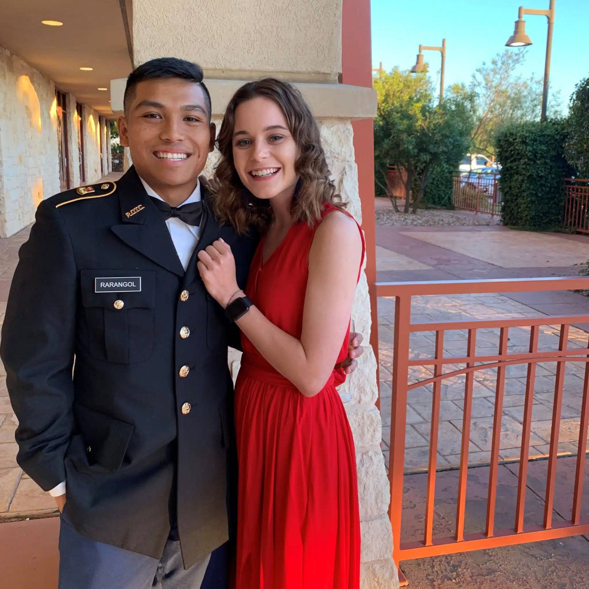 photo of couple, man is wearing military uniform and woman is wearing red dress