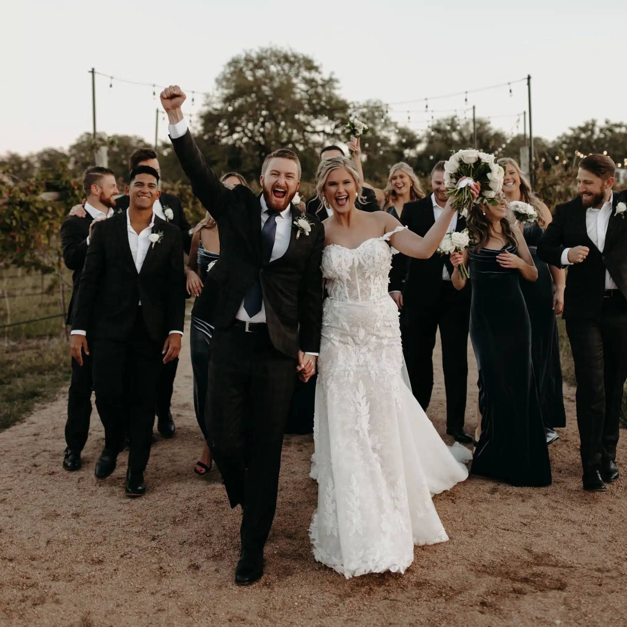 Photo of couple at wedding with their wedding party behind them