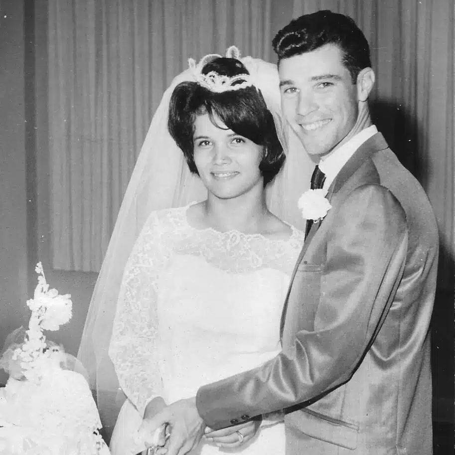 vintage black and white photo of couple in wedding attire cutting their wedding cake