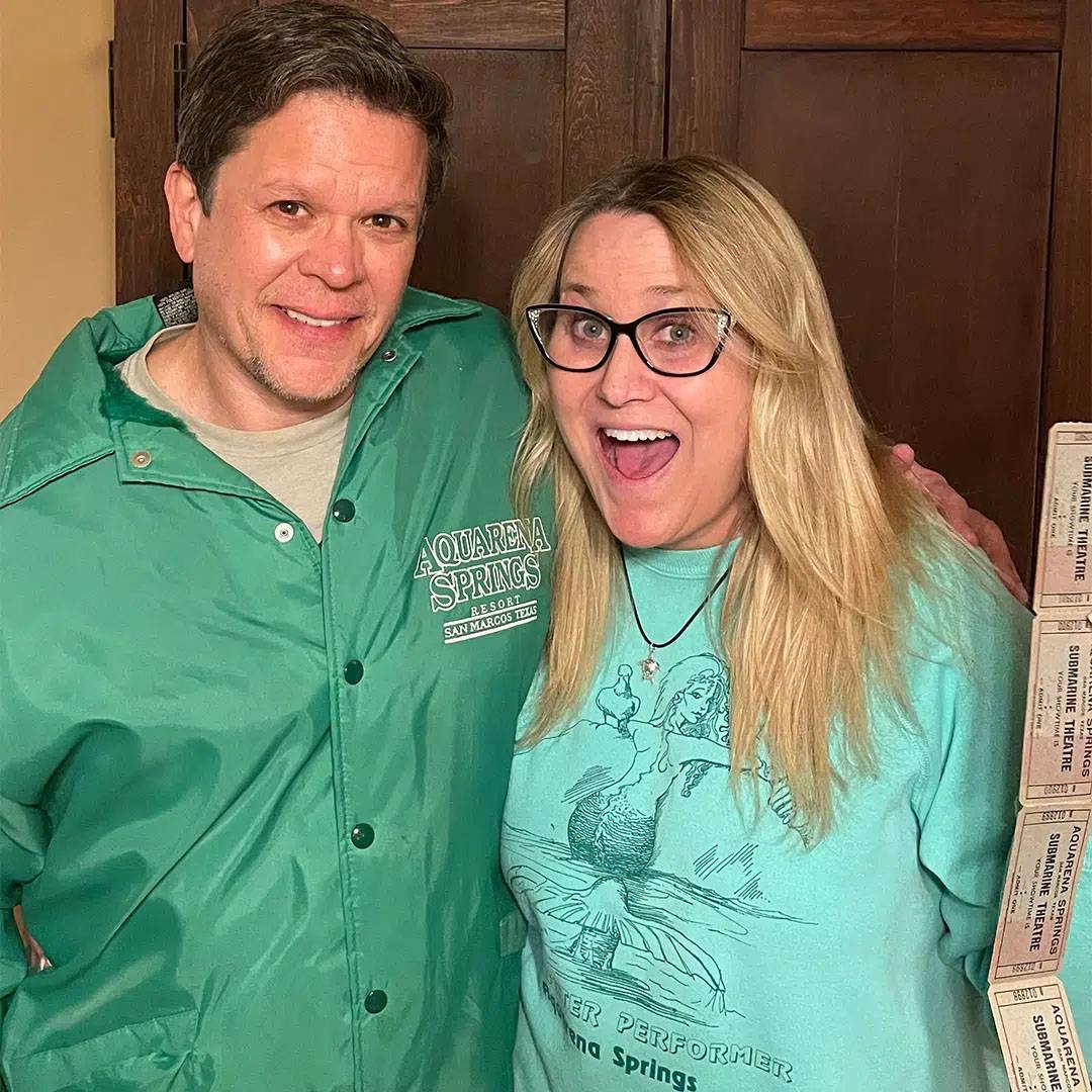 Photo of couple standing together and smiling while wearing aqaurena springs merch