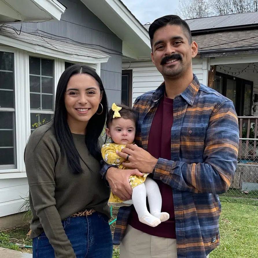 Photo of couple standing with their baby