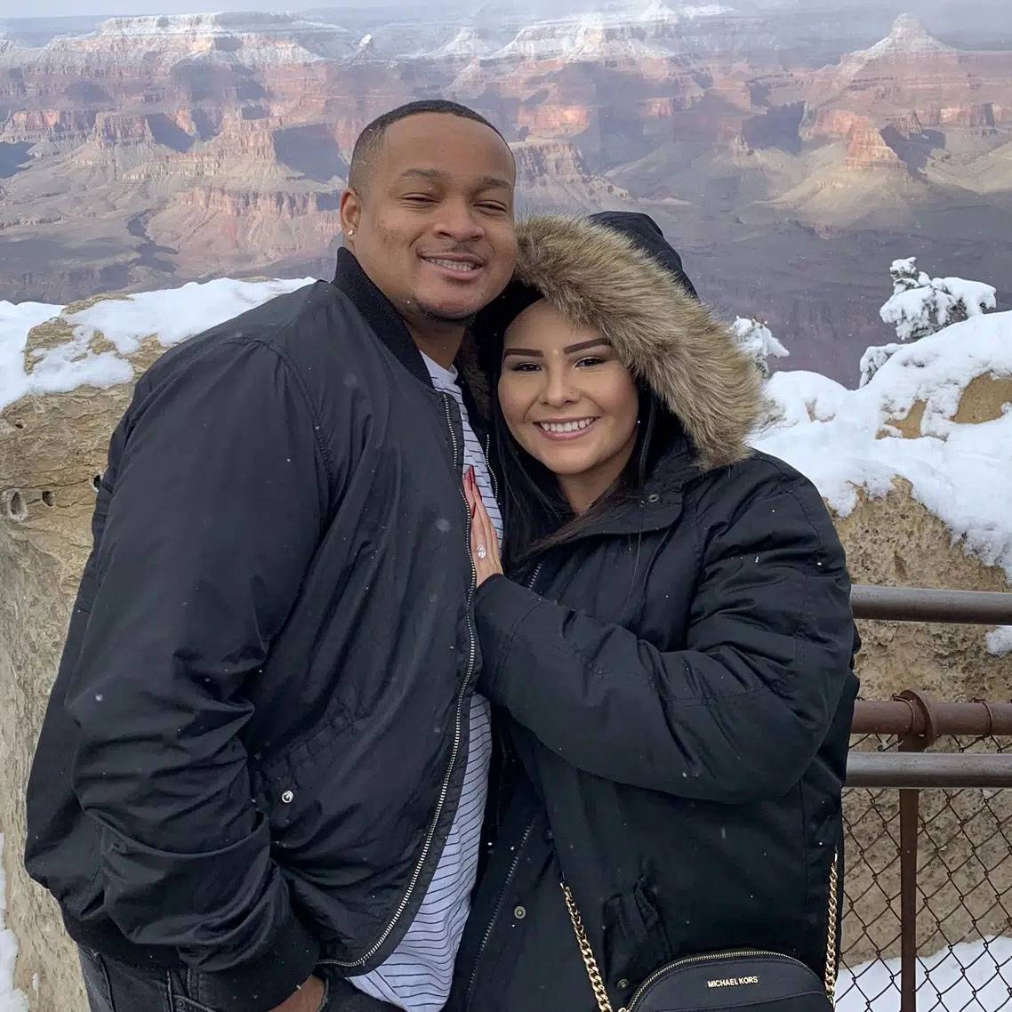 Photo of couple standing together on a mountain ridge