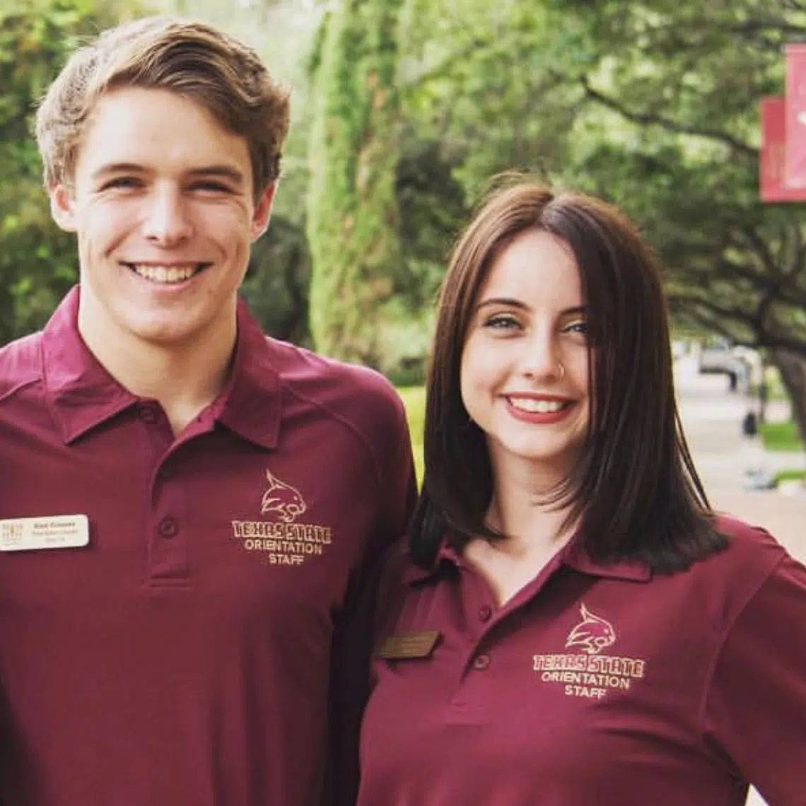 Photo of couple standing together smiling wear TXST Orientation Staff tshirts