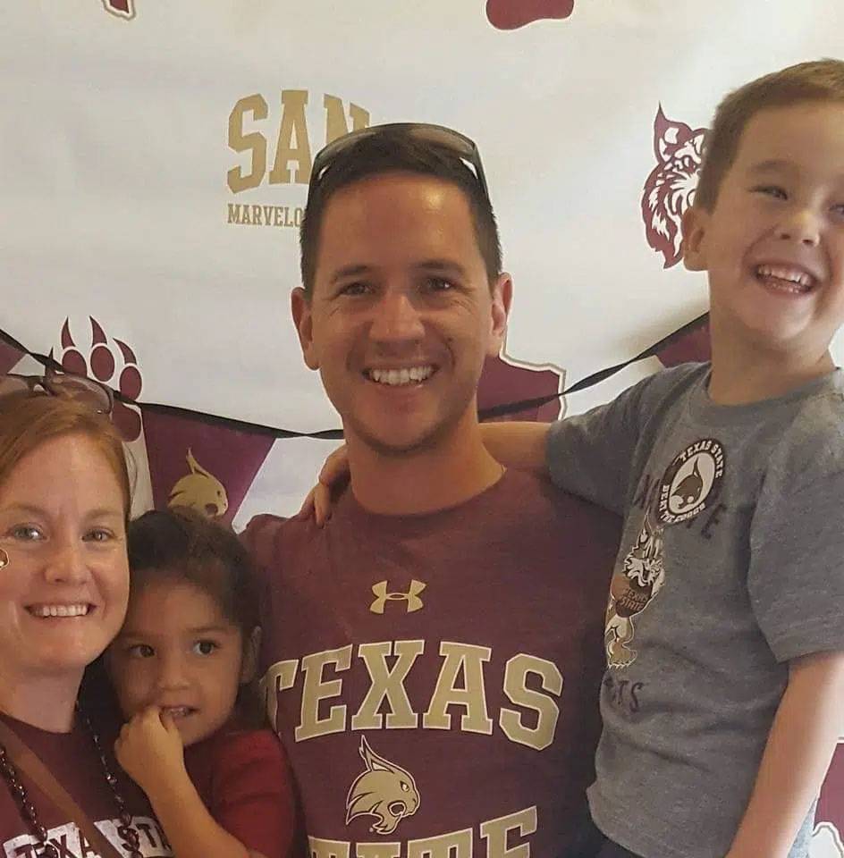 Photo of couple with two kids wearing TXST merch