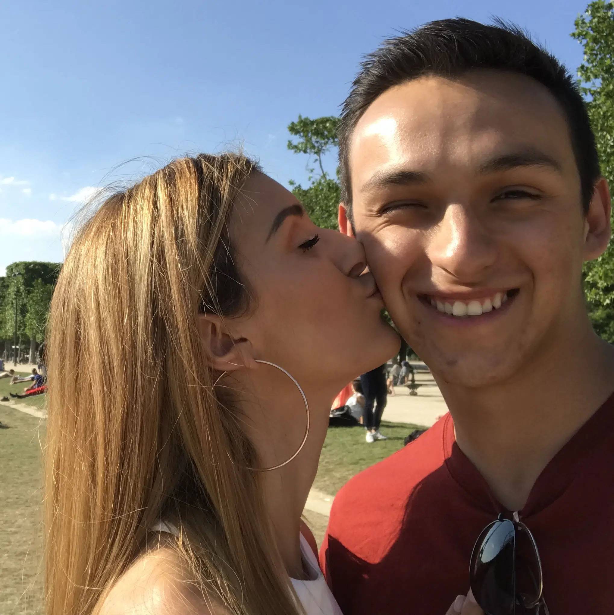 Selfie of couple with woman kissing man on cheek