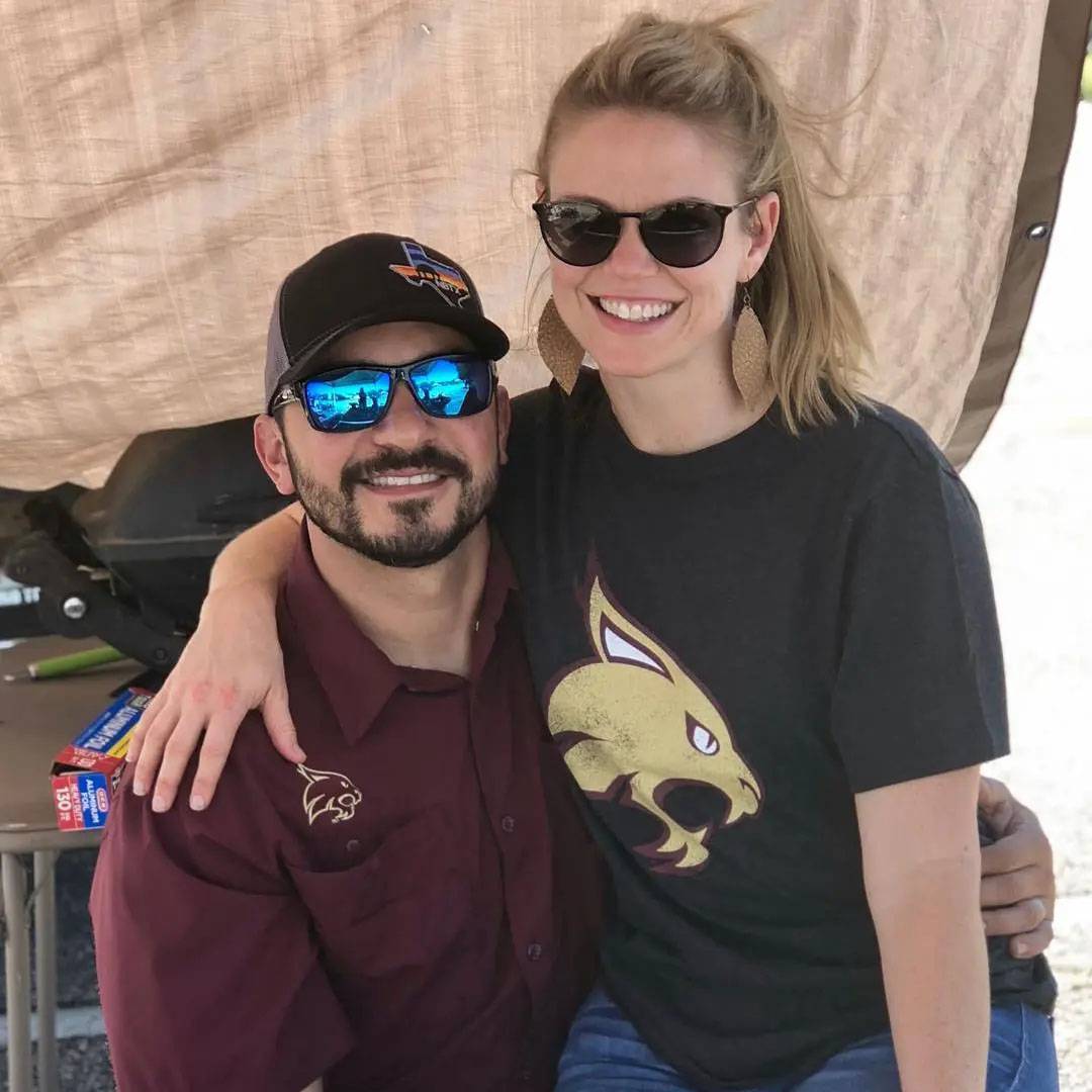 Photo of couple sitting together smiling wearing TXST shirts