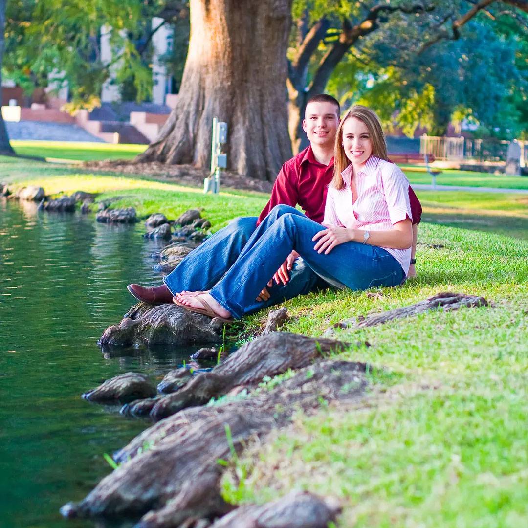 Photo of couple sitting at river together