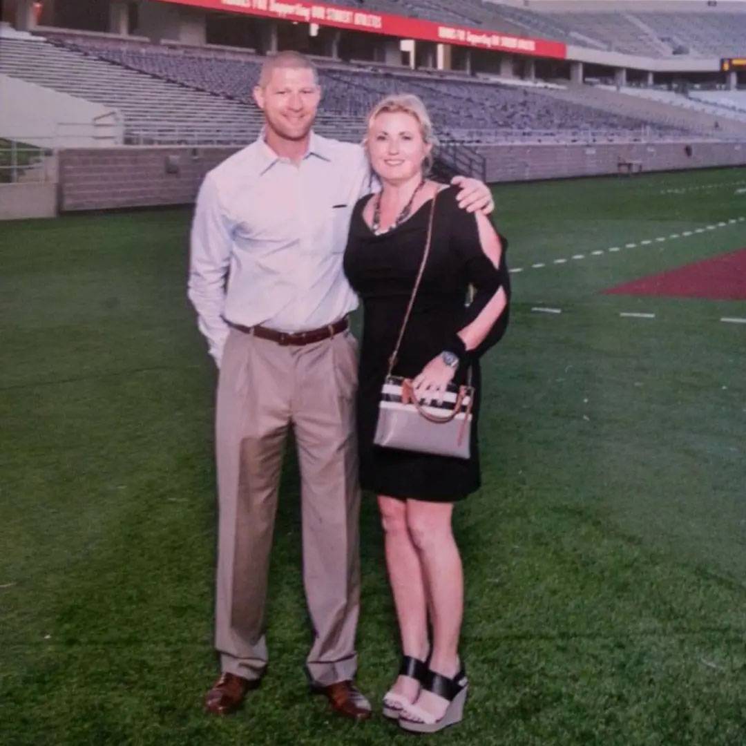 photo of couple smiling together on a football field