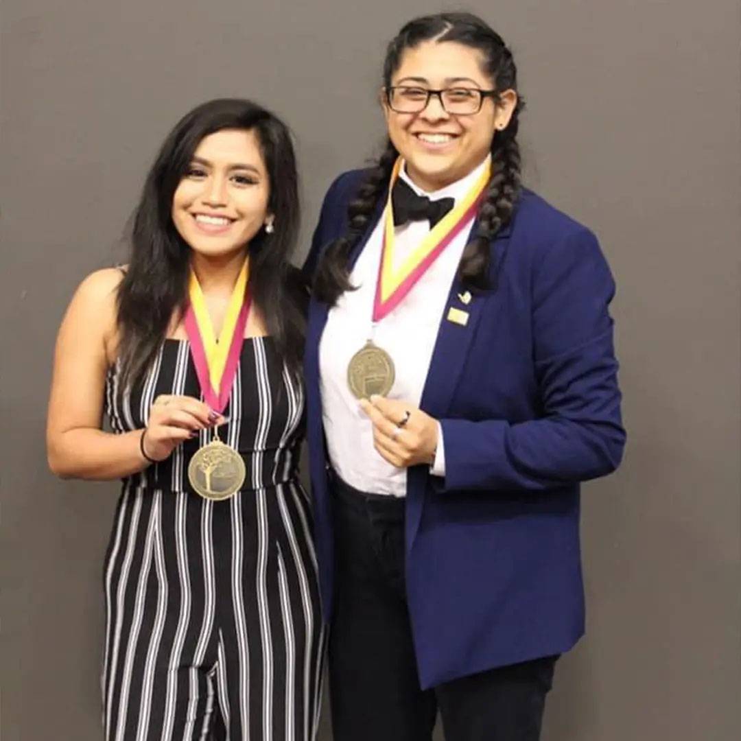 photo of two women smiling with gold medals