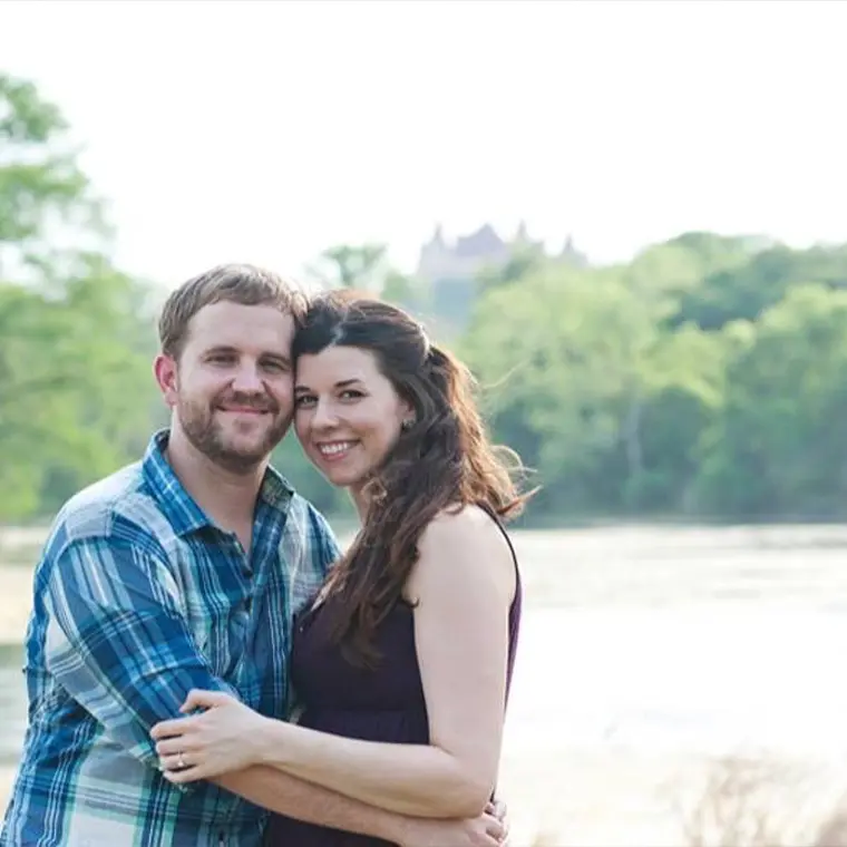 Photo of couple holding each other next to a lake