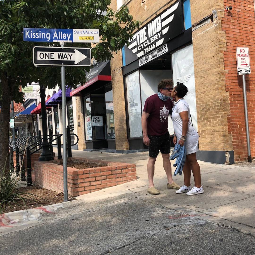 Photo of couple kissing next to the kissing alley