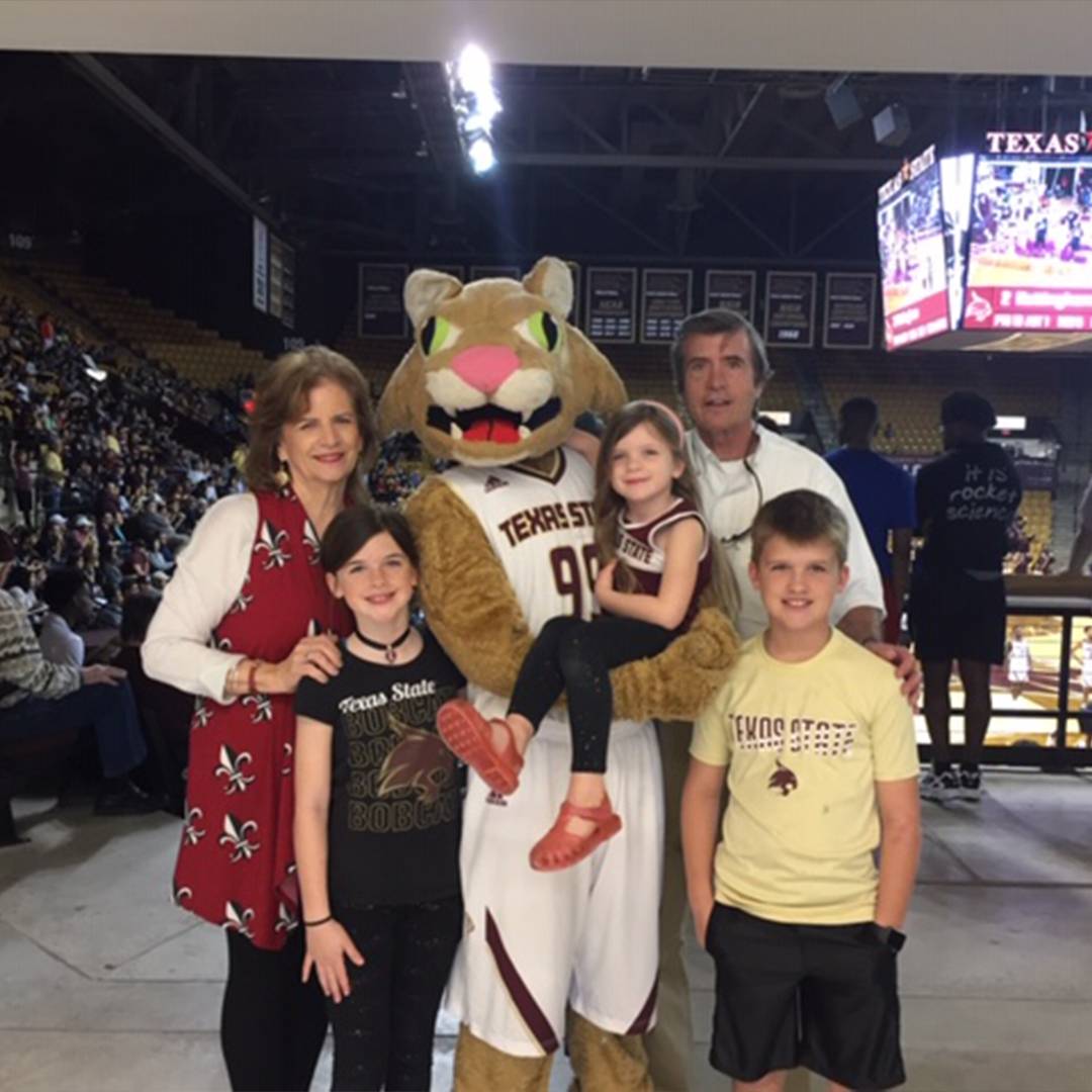 Family photo at TXST basketball game with Boko the mascot