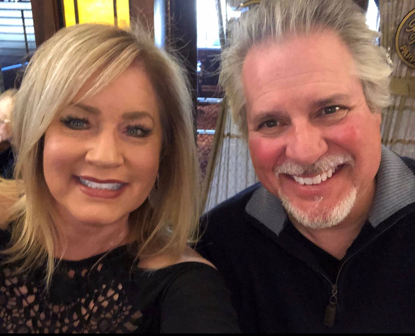 photo of couple smiling next to each other in a restaurant