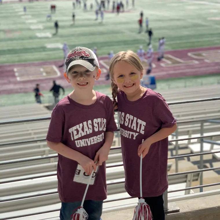 photo of two kids at TXST football game