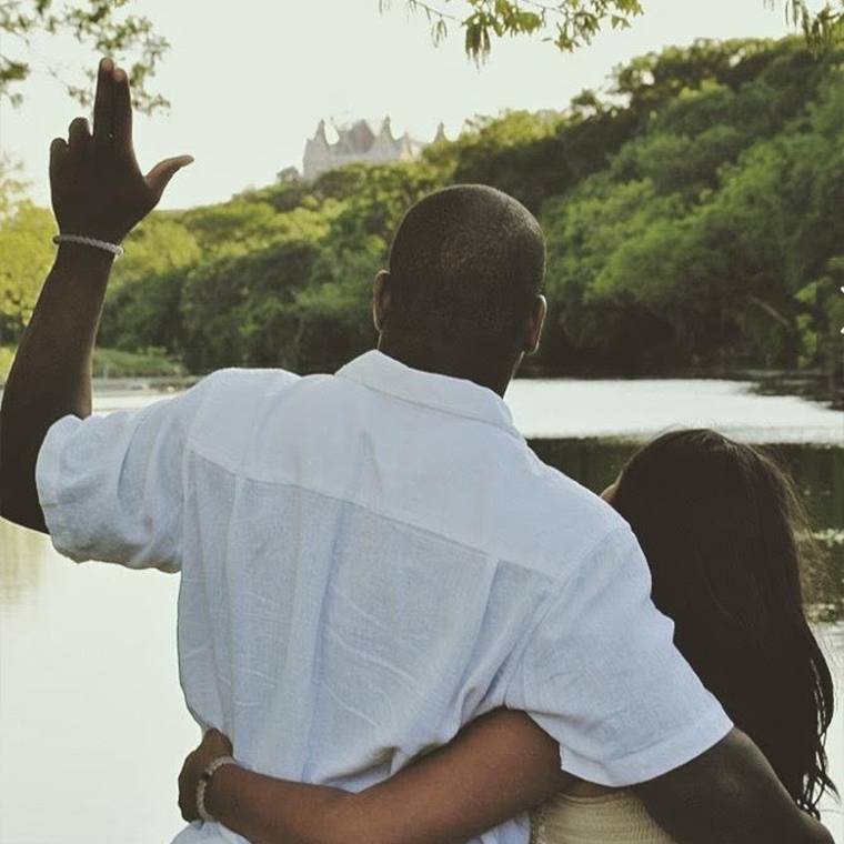 photo of back of couple, holding up TXST hand signs