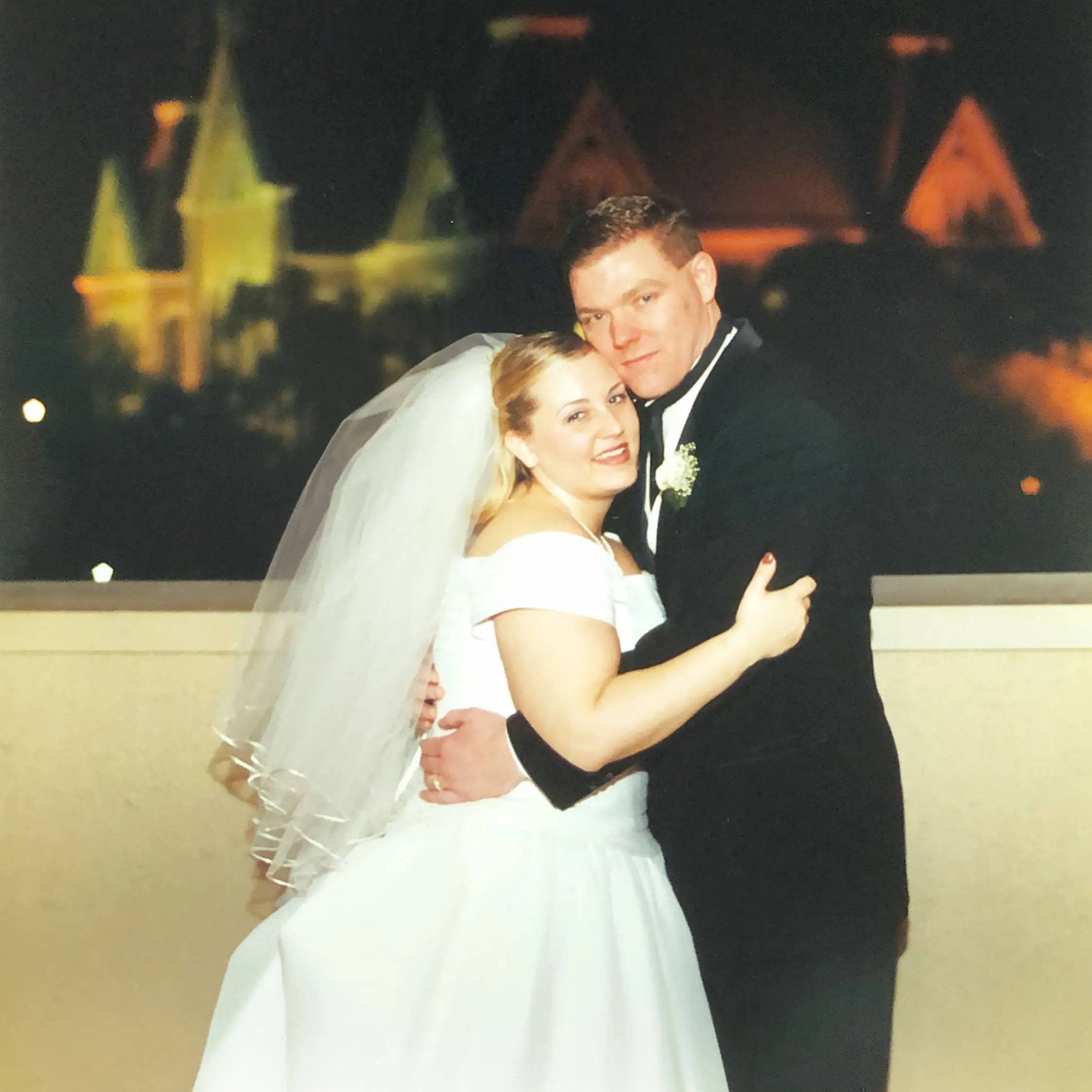 Photo of couple at their wedding with old main in the background