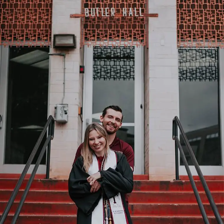 photo of couple smiling against butler hall