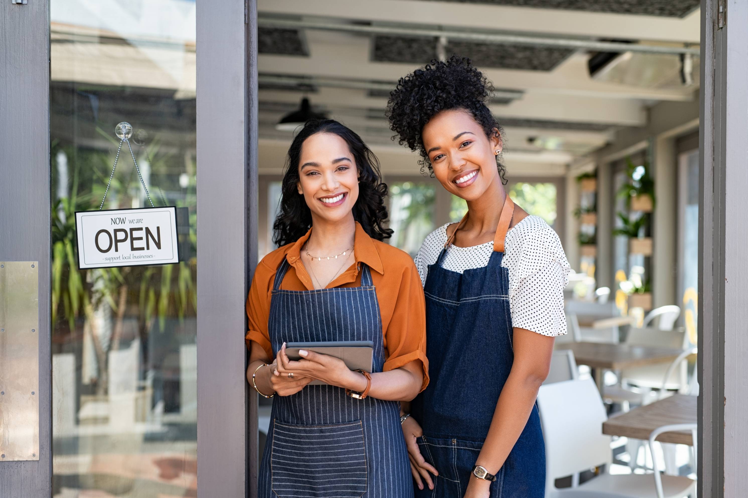 Two women standing in front of their shop.