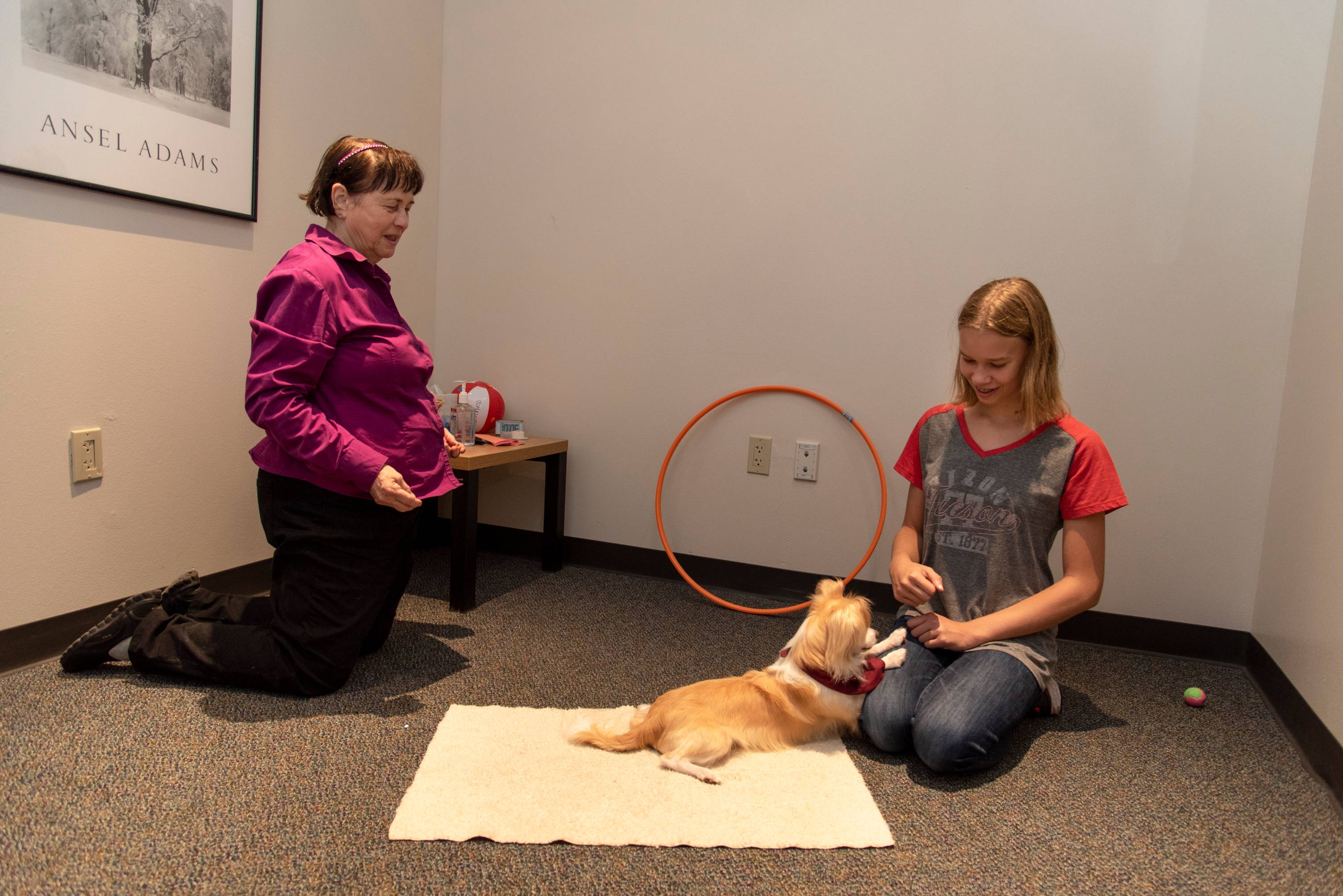 Professor working with student and dog