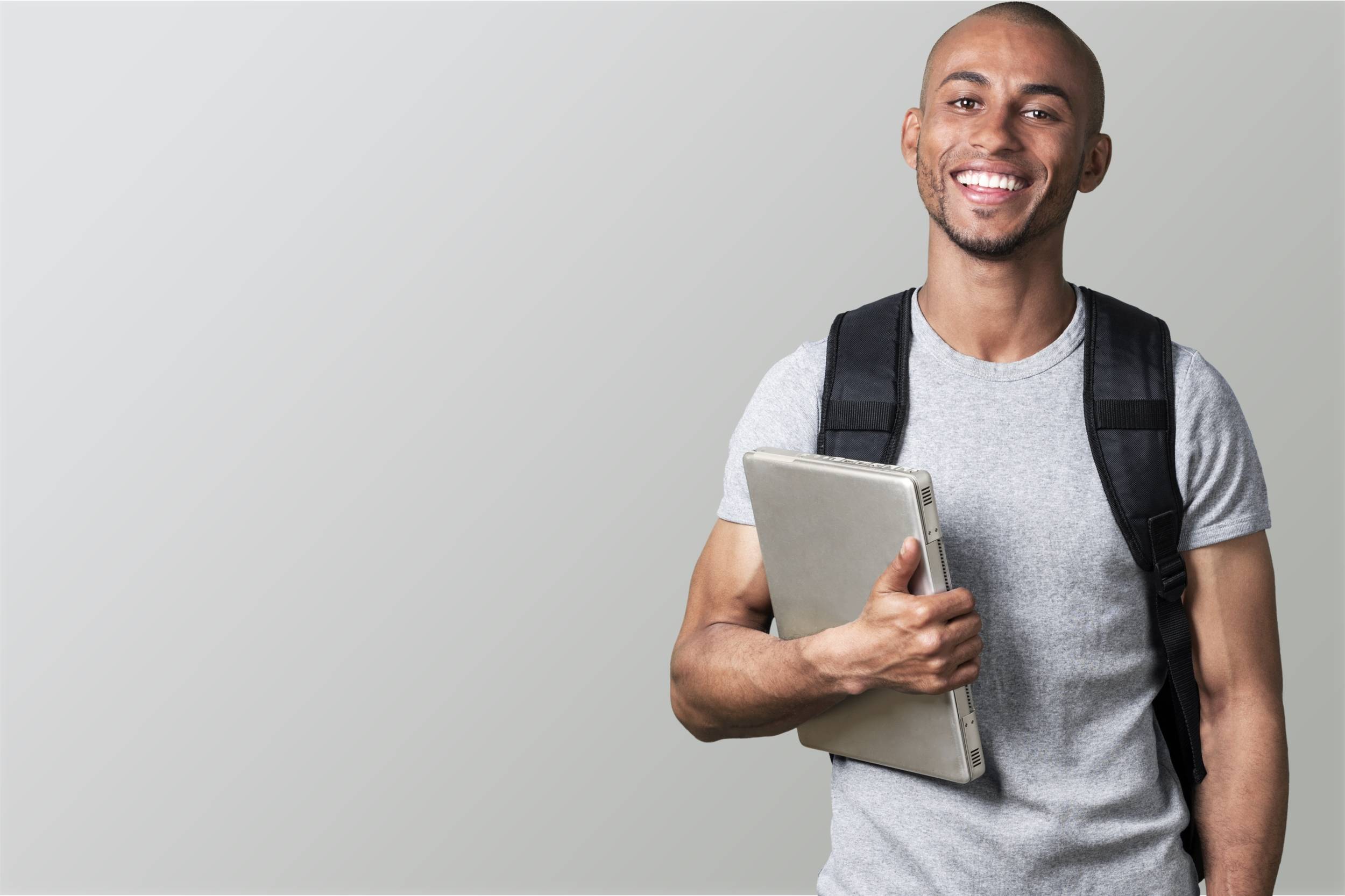 Male student holding laptop