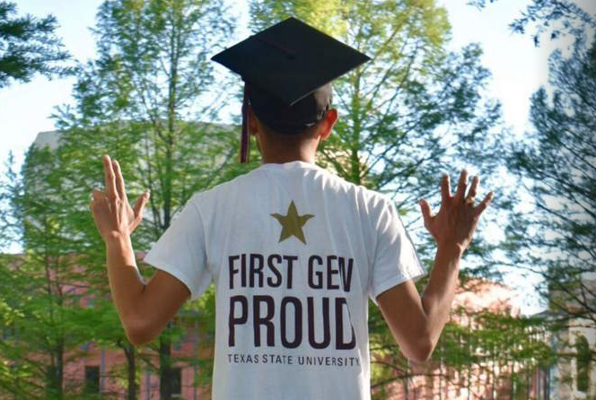 First gen student wearing graduation cap and gesturing Texas State Bobcat hand signs