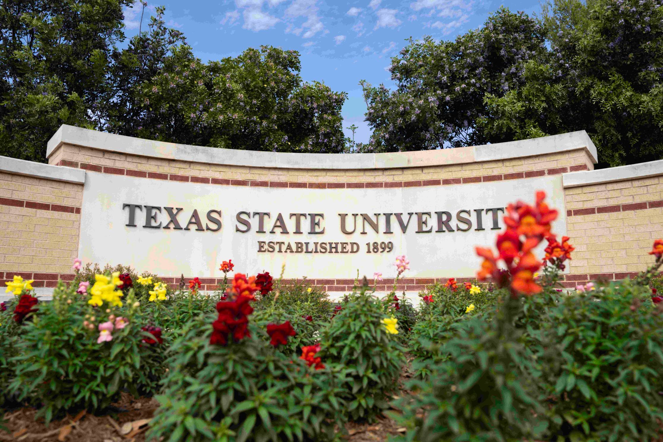 University sign with snapdragon flowers