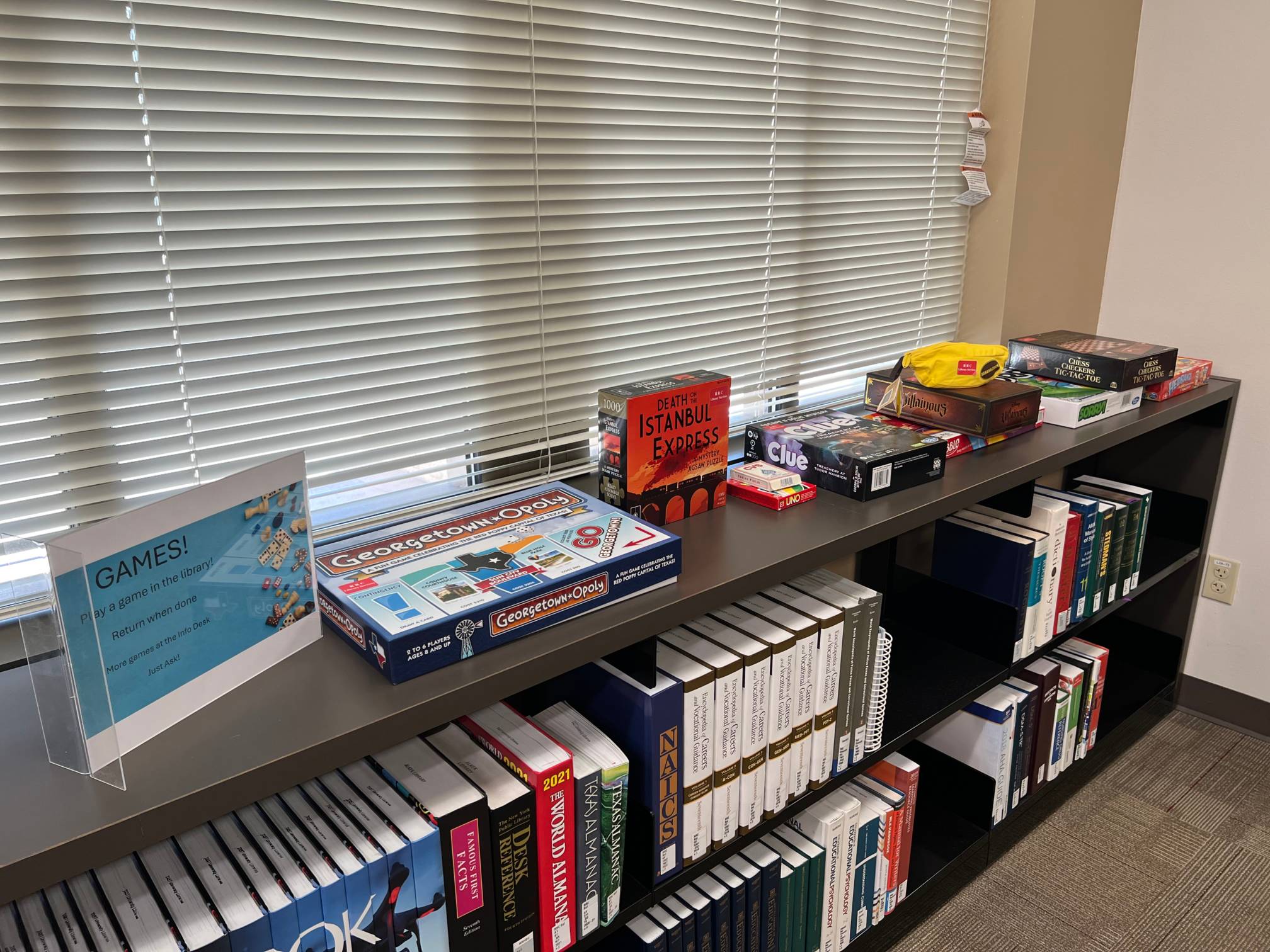 assorted board games on top of a book case