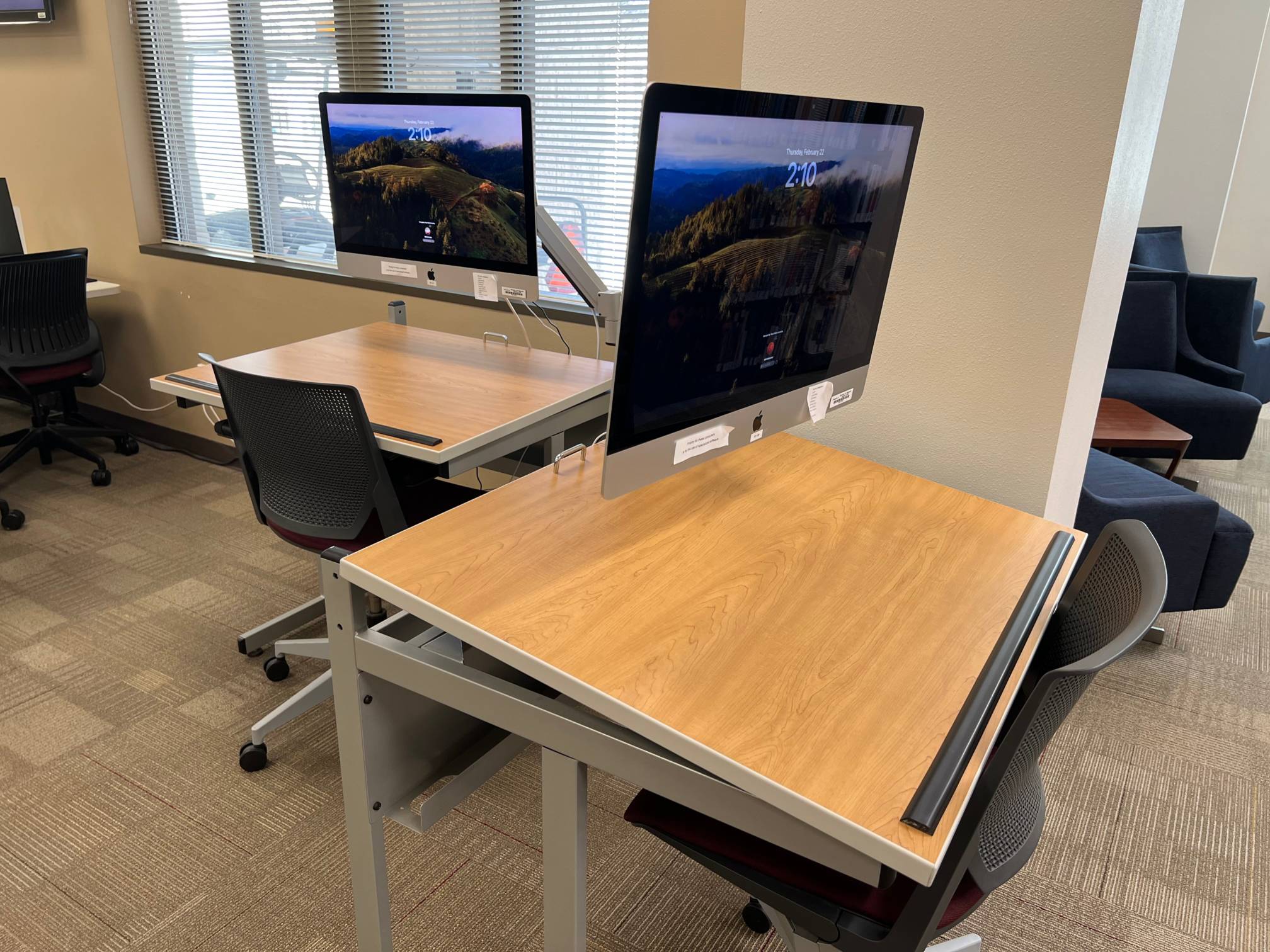 iMacs on individual drafting tables each with a chair