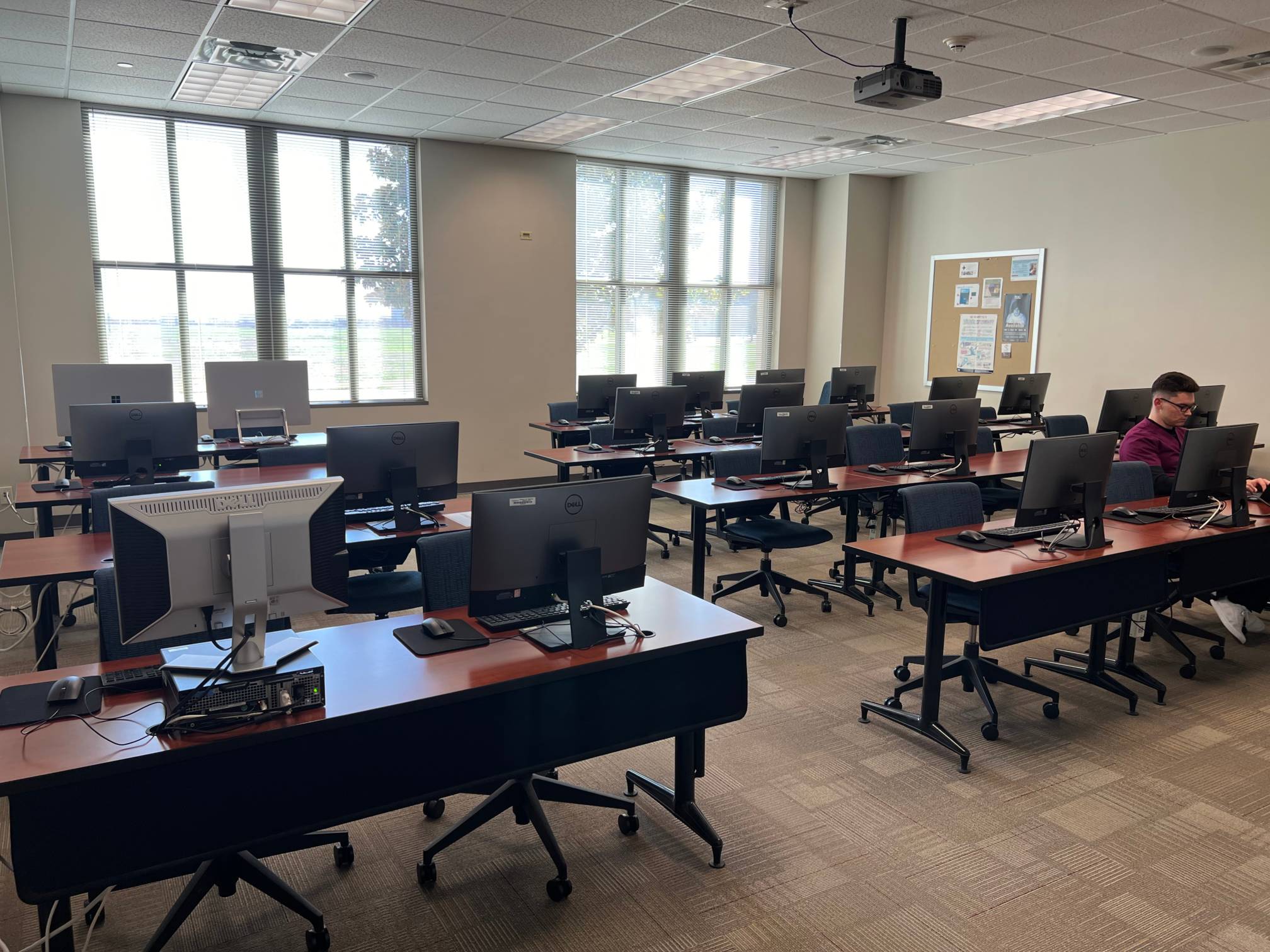 a computer lab with computers, tables, and chairs