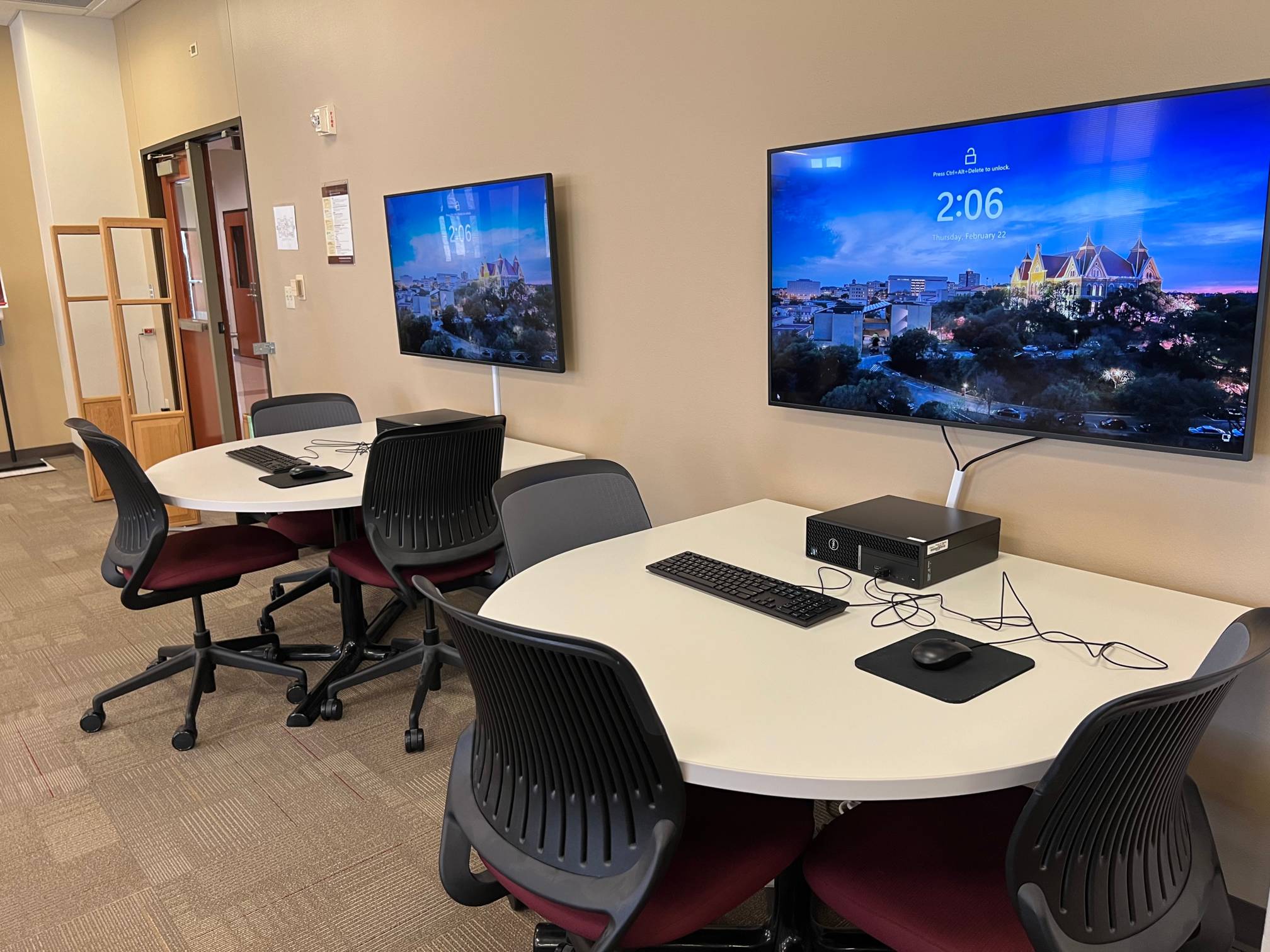 U-shaped tables each with a pc and a large monitor