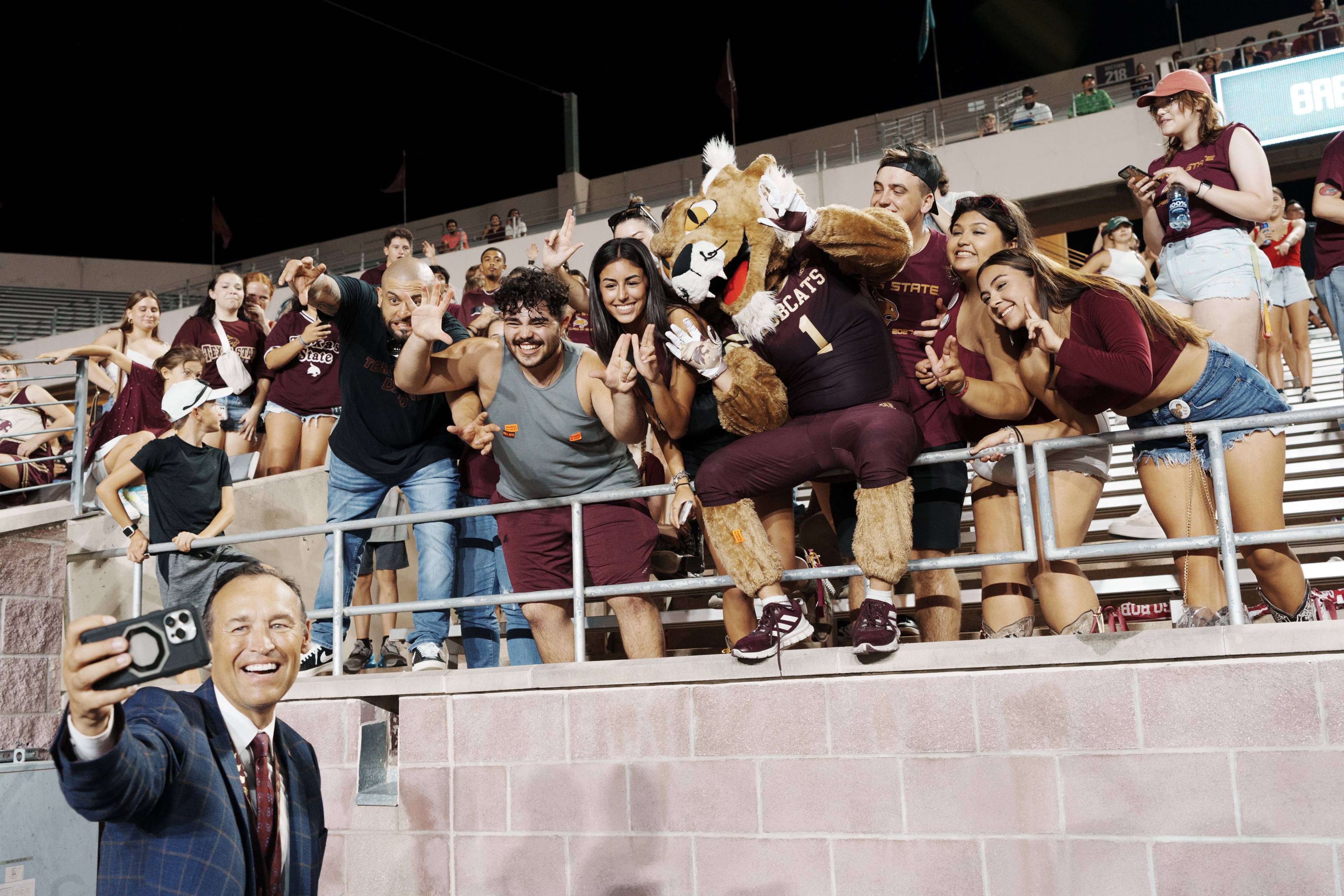 the txst president taking a selfie with students 