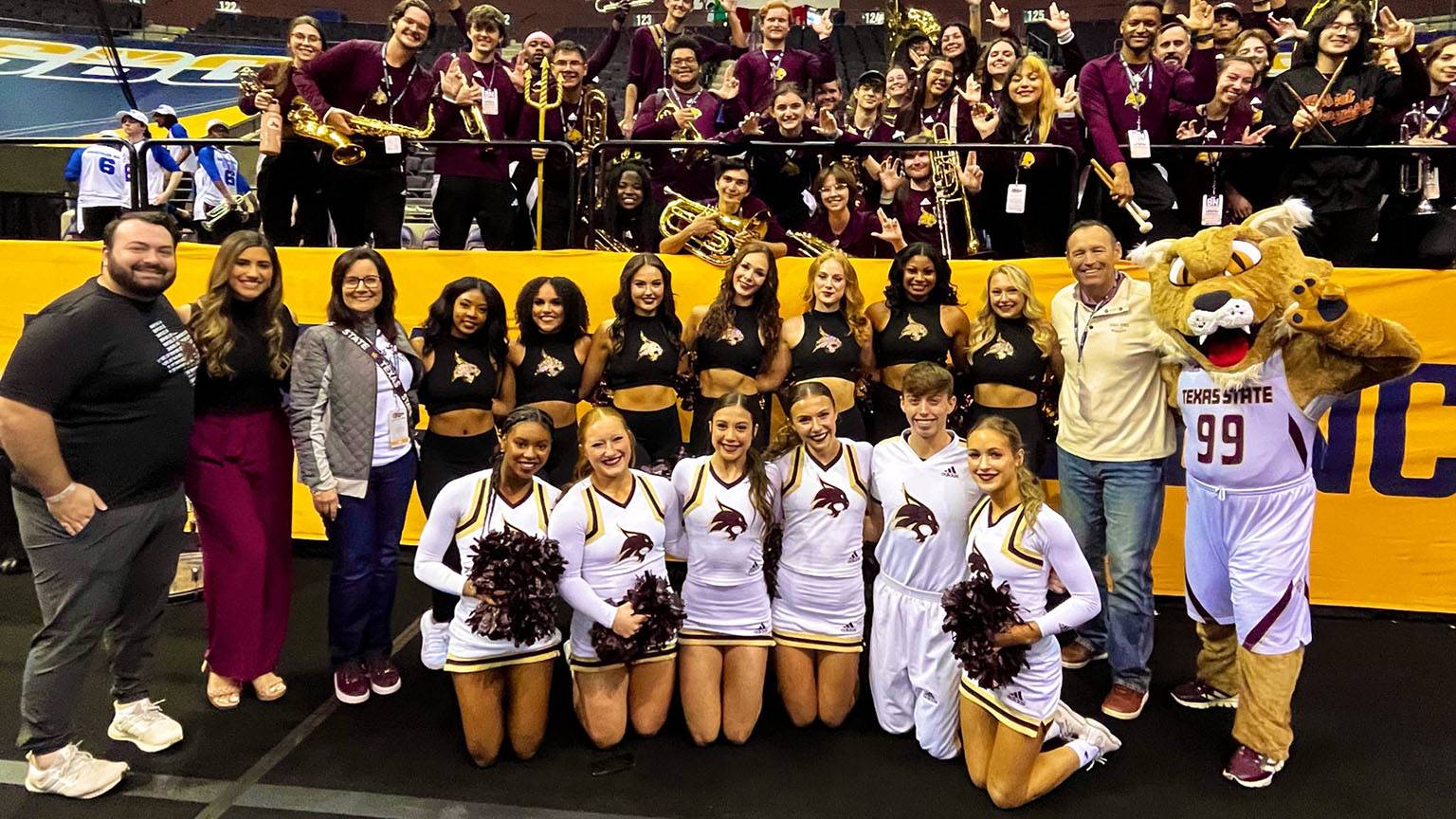 President Damphousse and First Lady Damphousse pose for a photo with TXST cheerleaders.