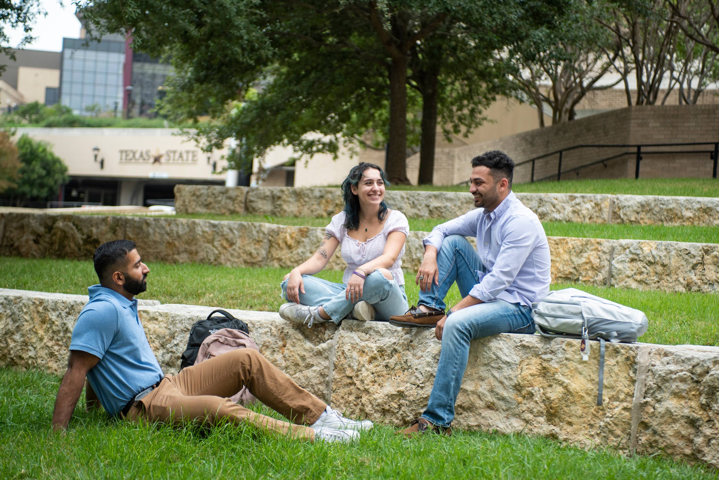 students conversing on the campus green