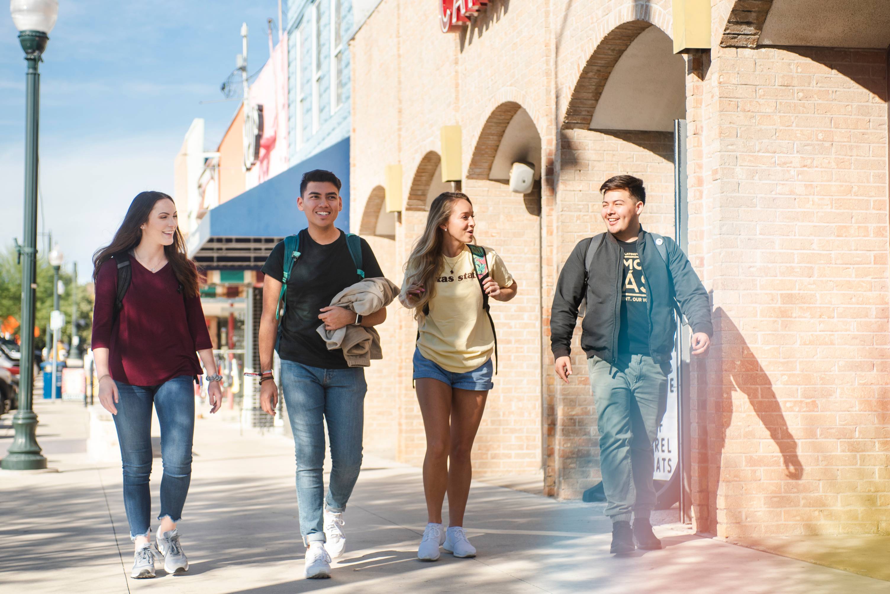 Four students walking in downtown San Marcos 