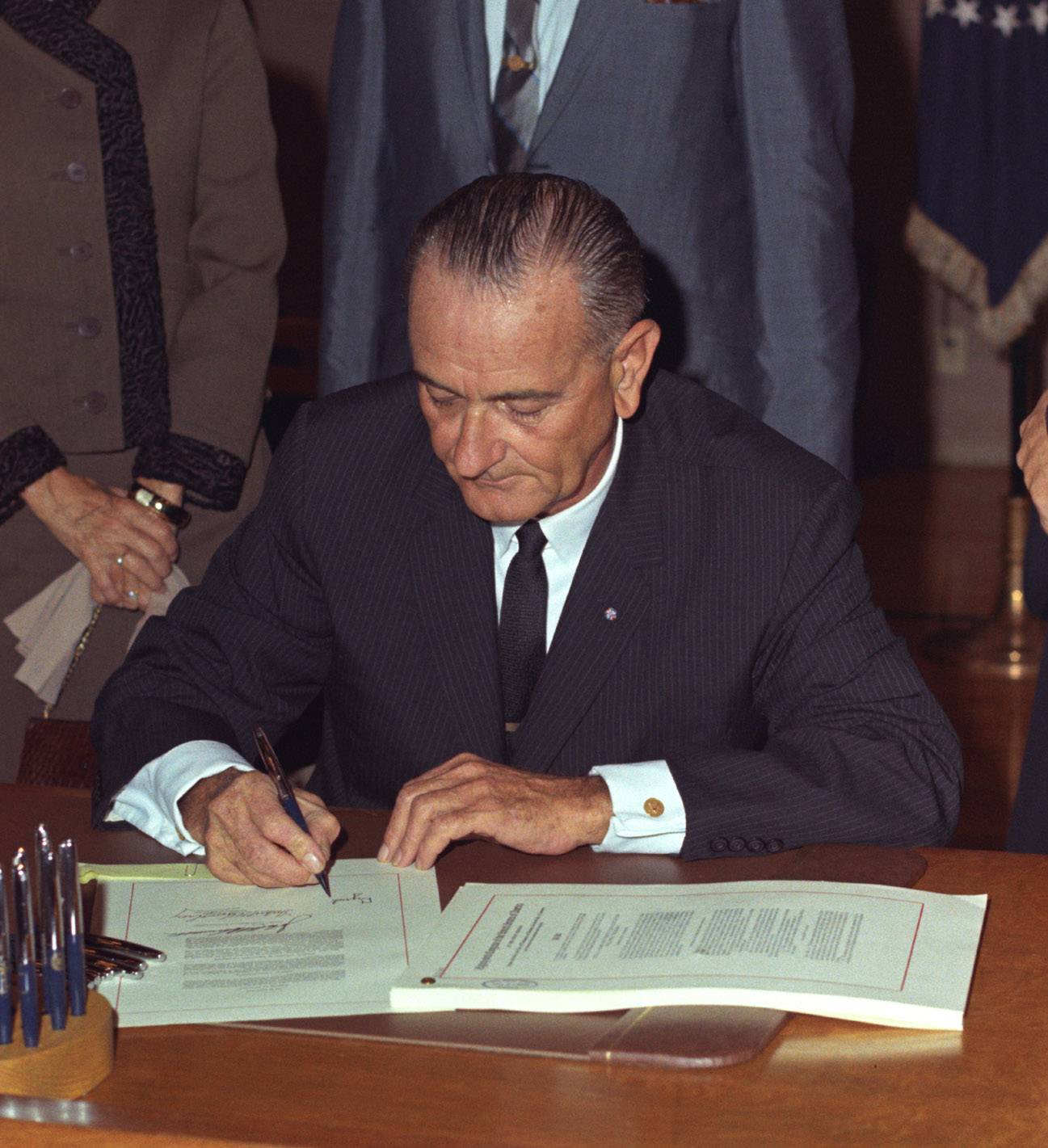 president johnson signing paperwork on wooden desk