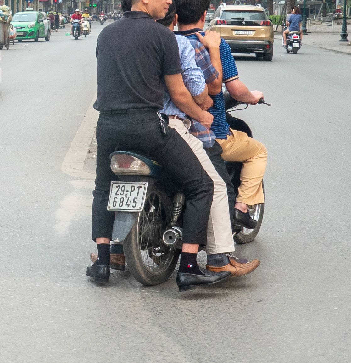 four grown men riding on one motorbike