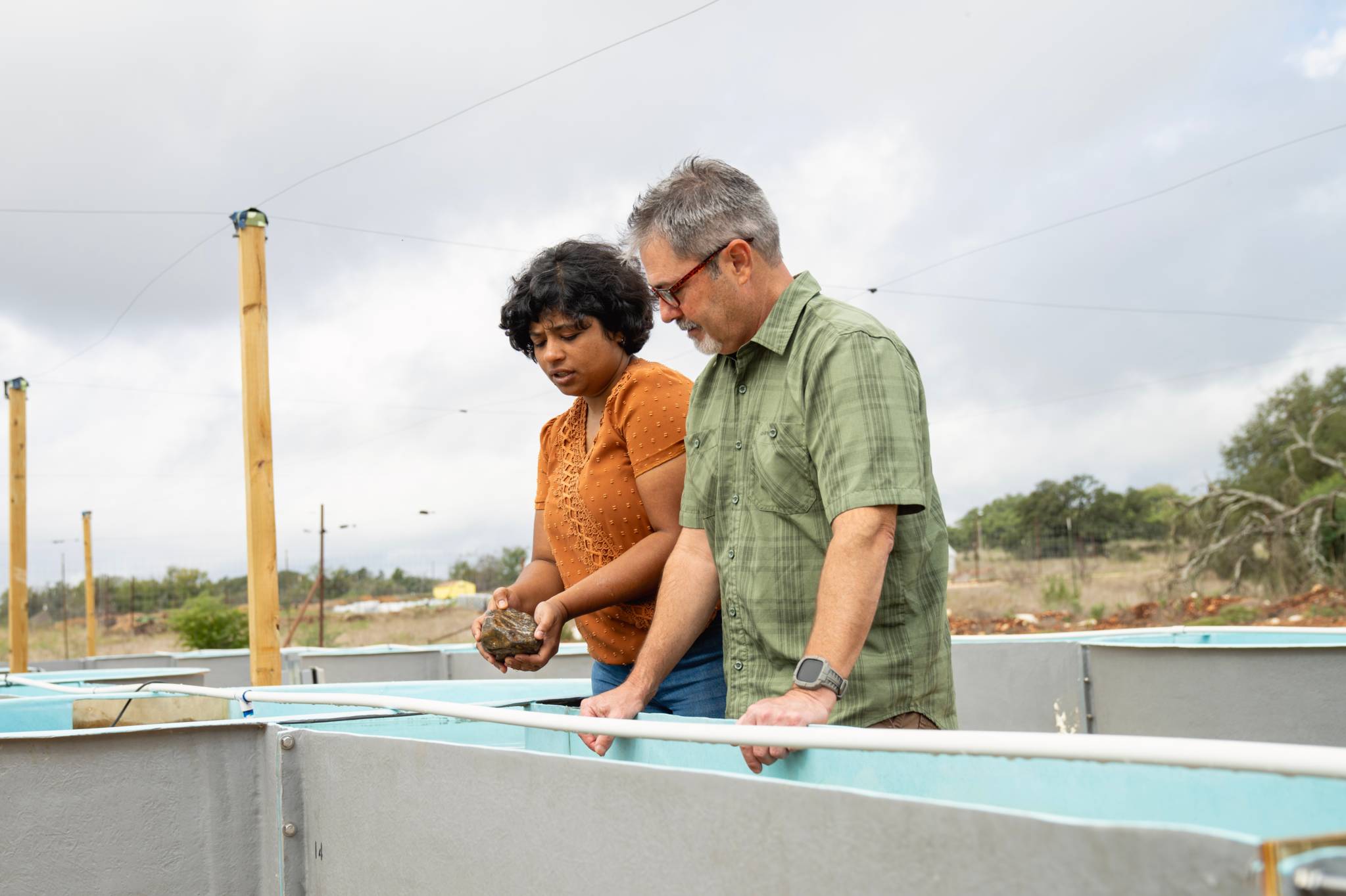 Weston Nowlin, at right, a professor in the biology department, and Parvathi Nair, a postdoctoral scholar in Nowlin's Aquatic Ecology Lab, examine the new experimental stream facility at Freeman Ranch.