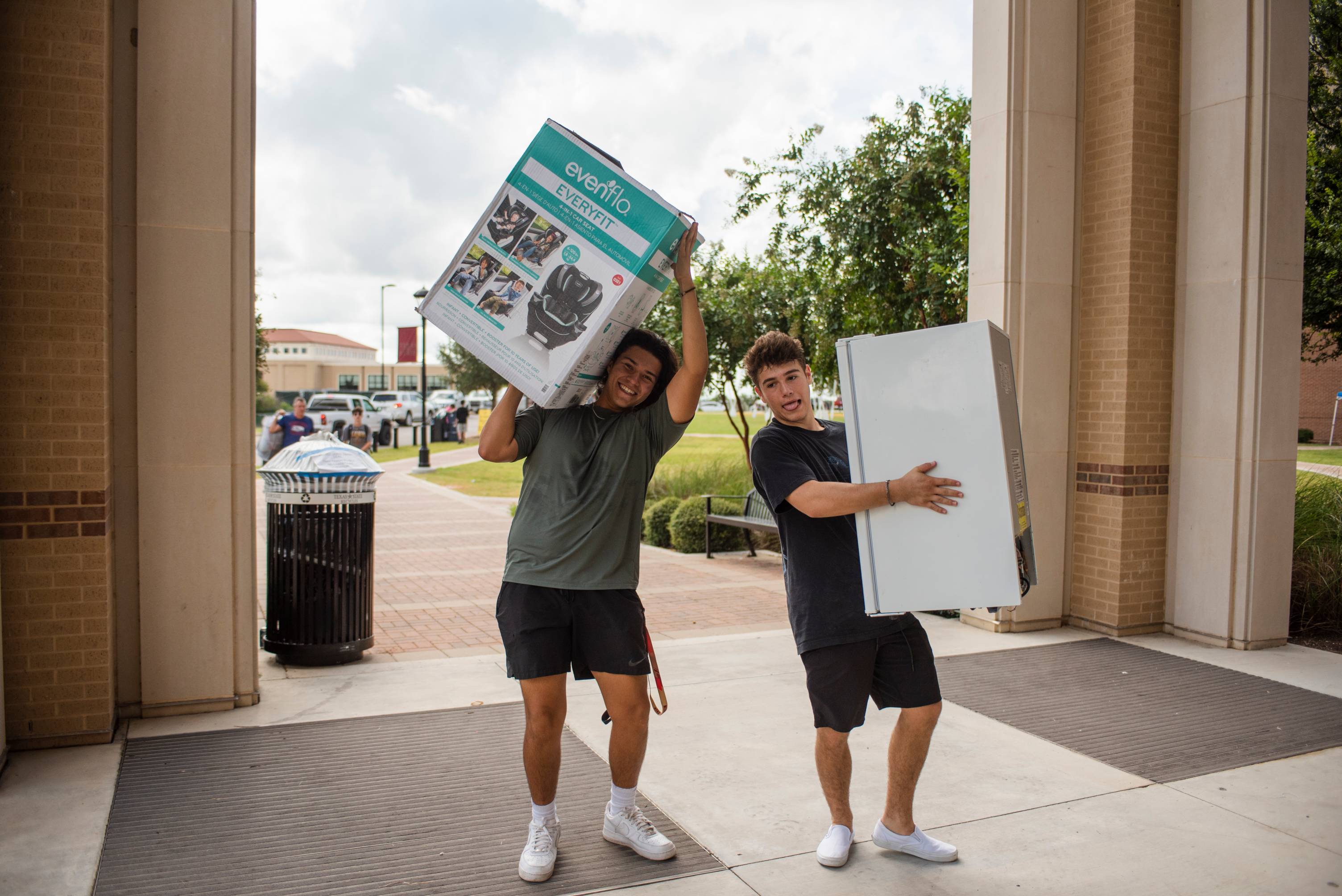 guys carrying boxes during campus move in 