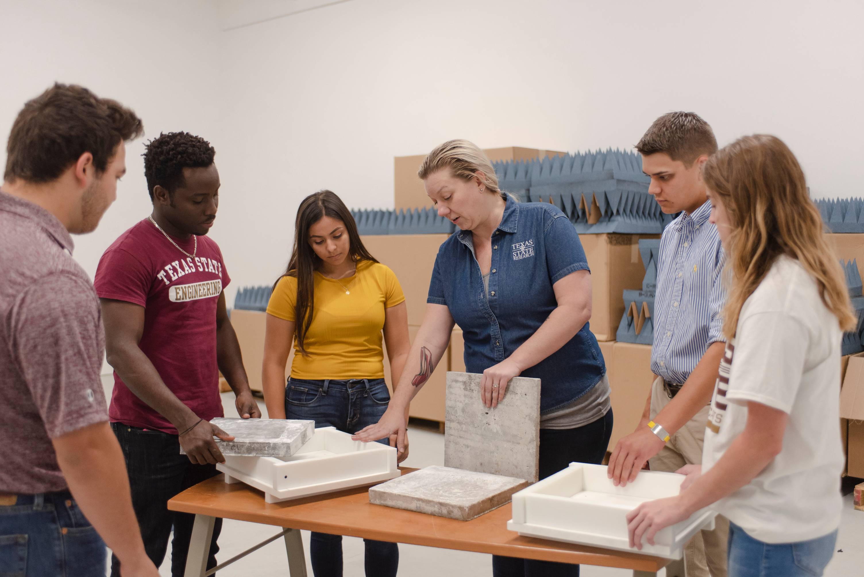 Bobcats are gathered in a group surveying several instruments while being taught by a TXST faculty member. 