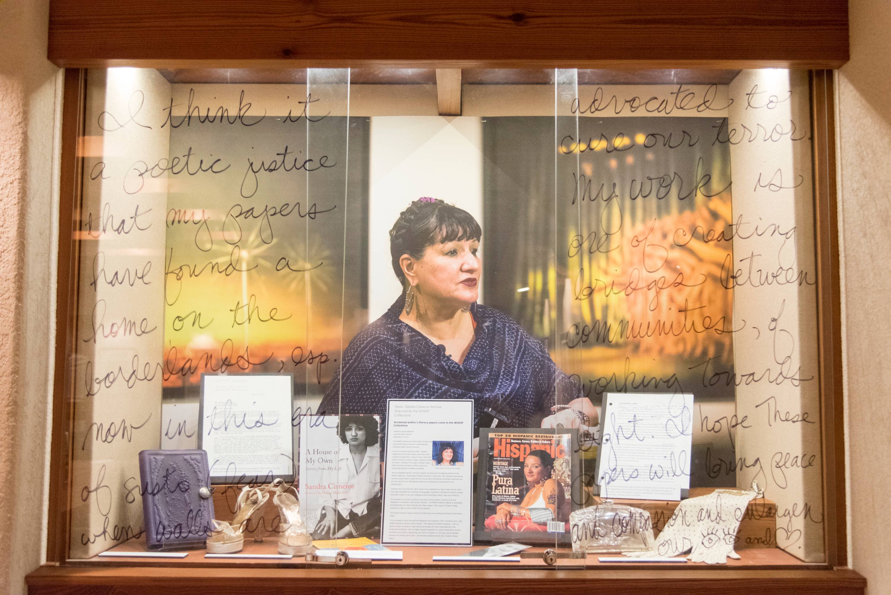  A display of Sandra Cisneros’ work that includes a message from the writer on the glass case. The archive includes several of her works, magazines, and other items. 