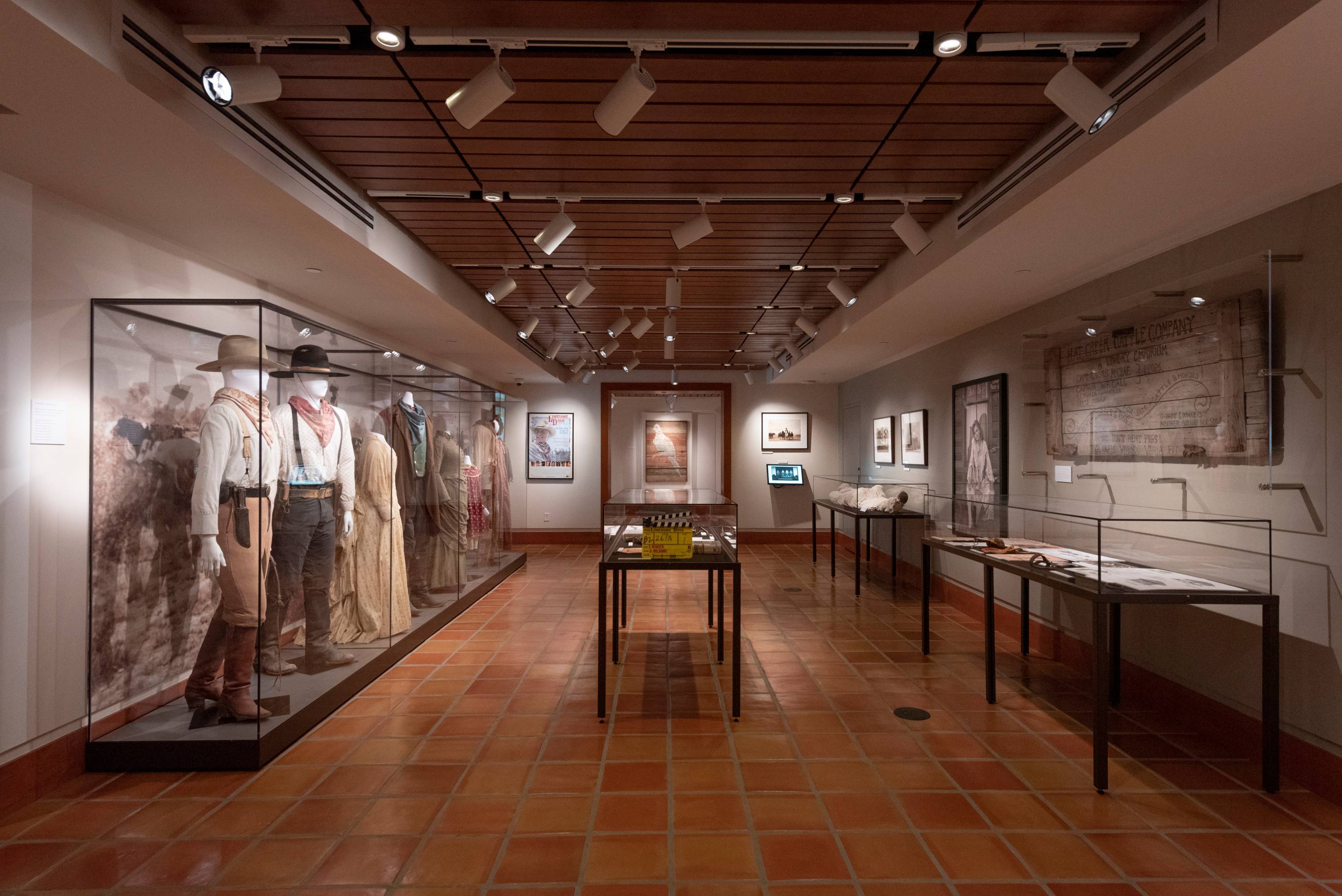 A photo of the Lonesome Dove exhibit in the Wittliff Collections; there are numerous components of the collection including costumes, props, photo stills, posters, and a number of other items. 