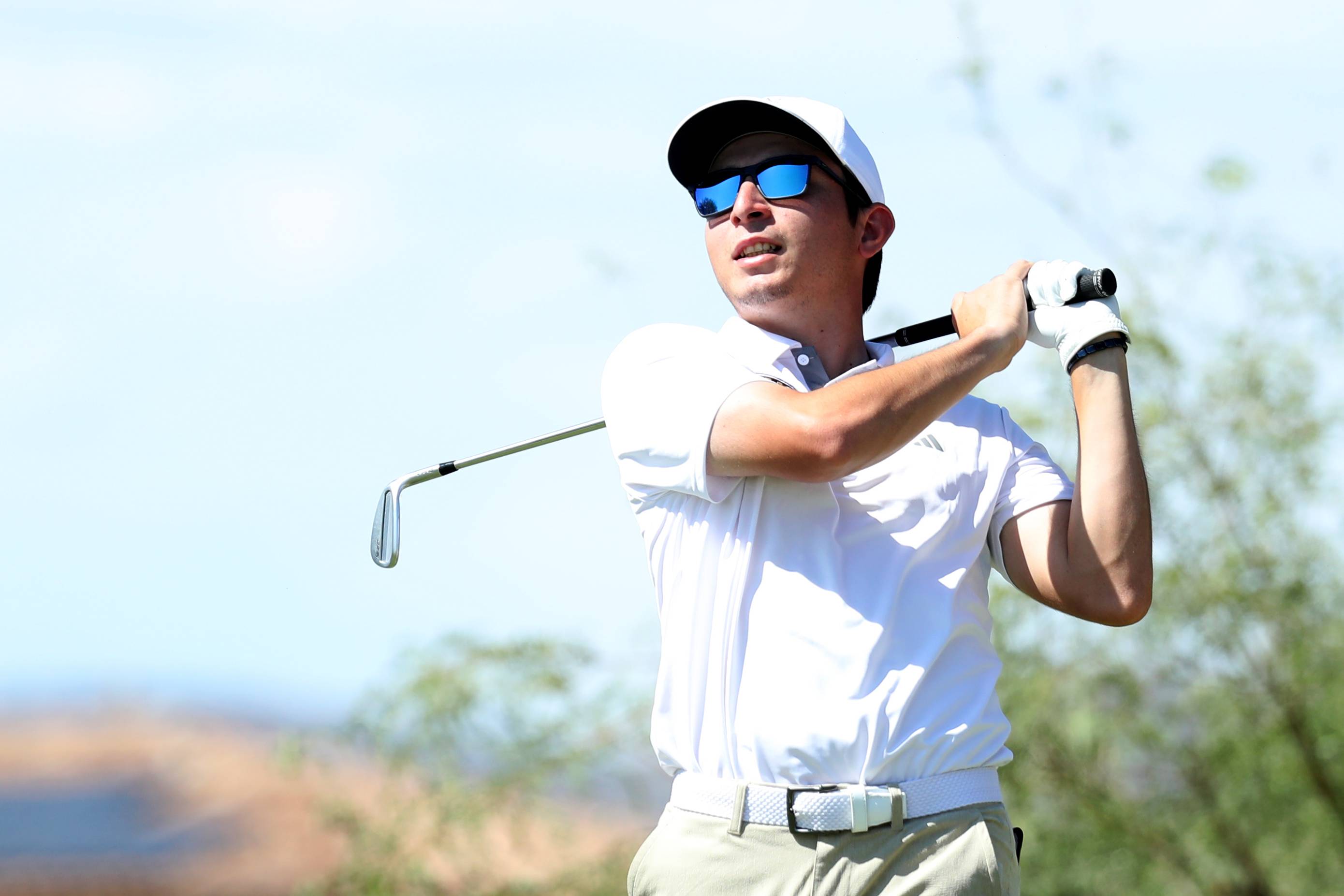 A Bobcat golfer post-swing, admiring his shot. 