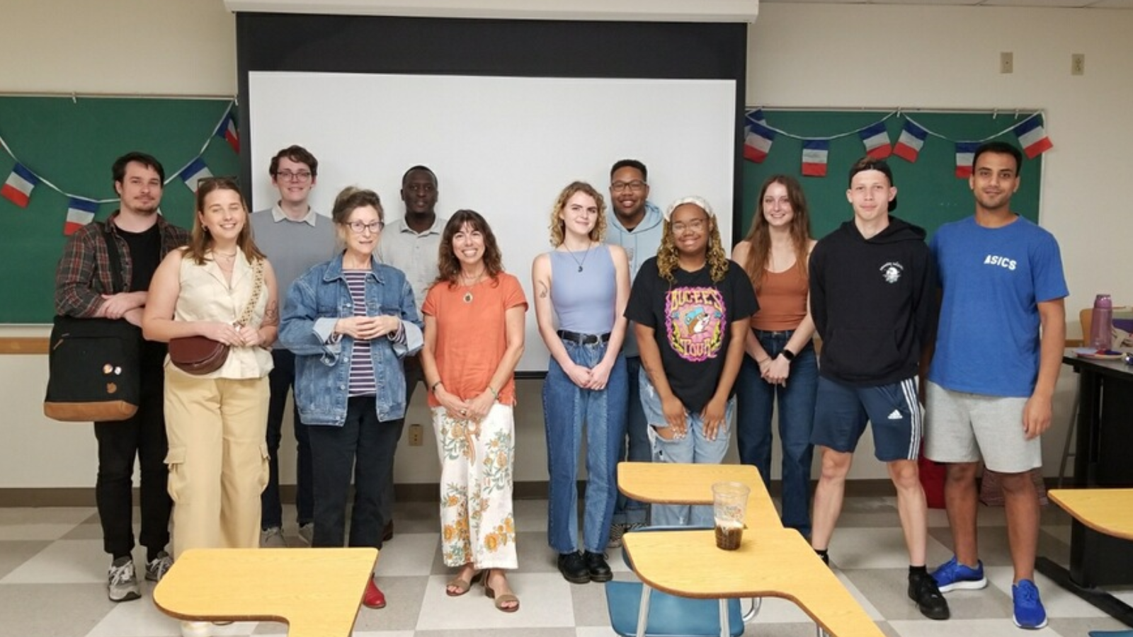 group of people standing in front of a classroom