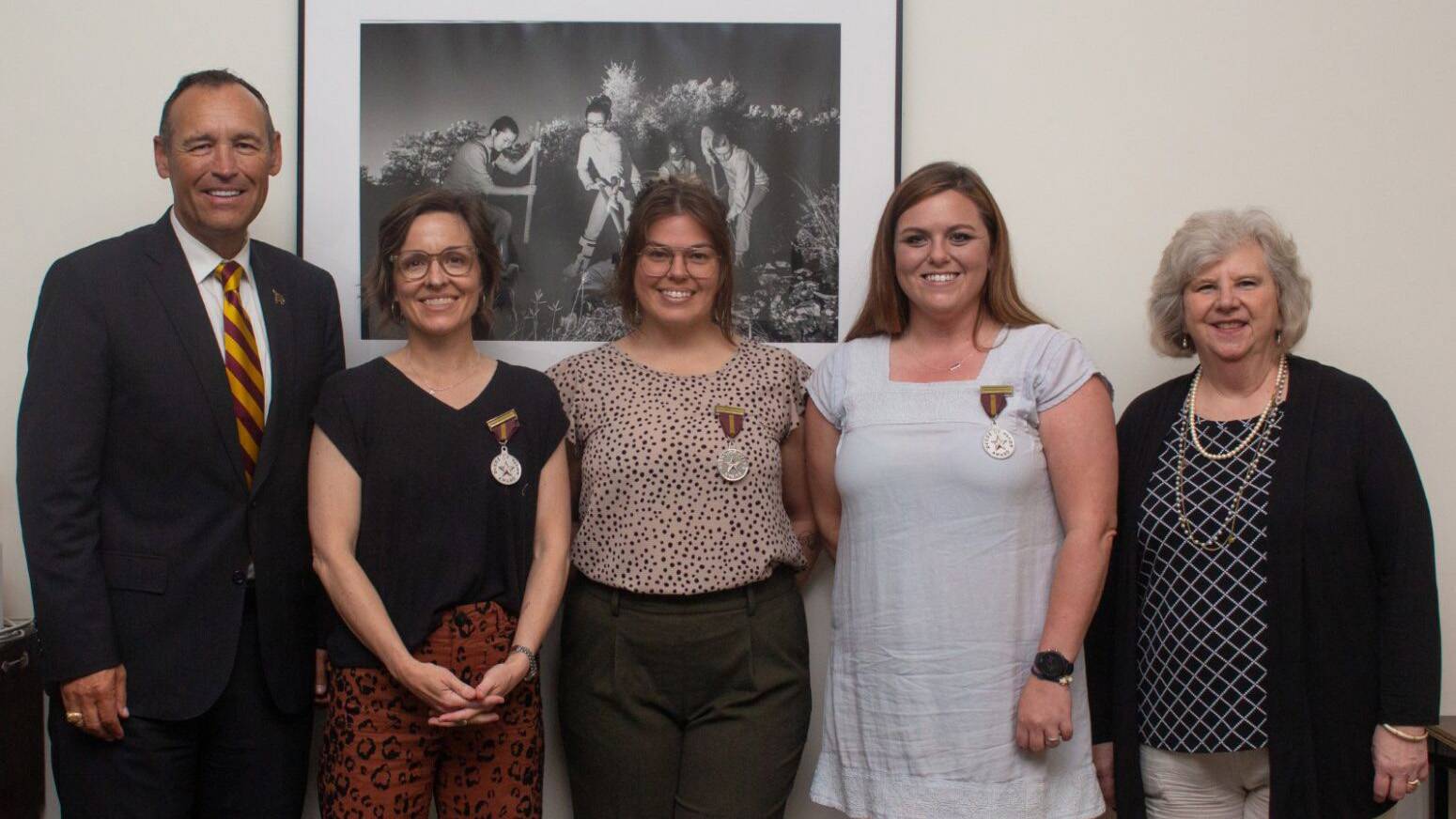 TXST President Kelly Damphousse, left, poses for a photo with the Deeds of Valor honorees.