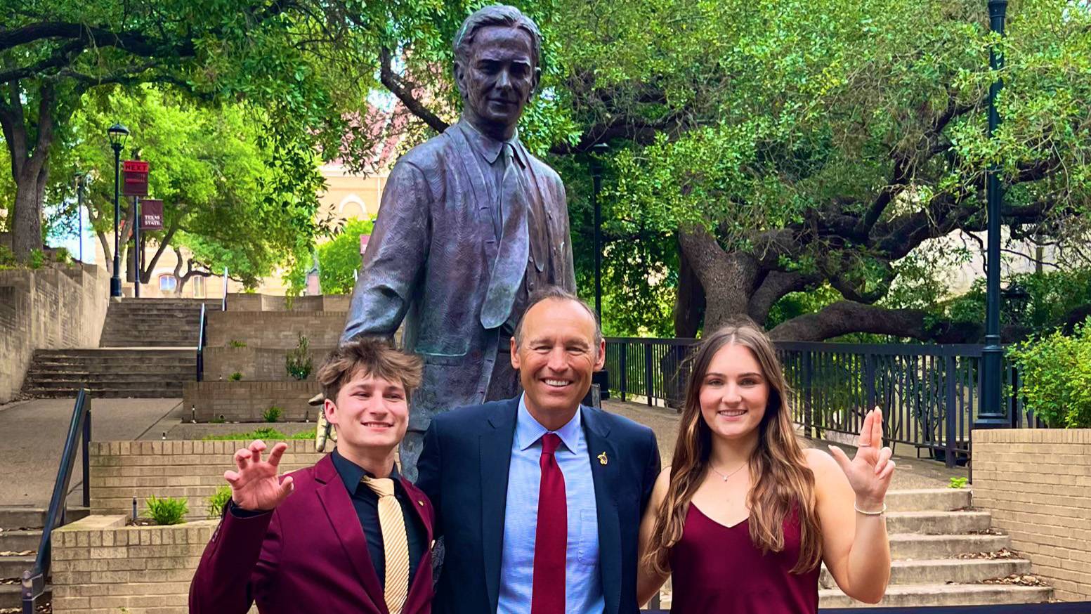 Student Body Vice President Donovan Brown, left, TXST President Kelly Damphousse, and Student Body President Olivia Alexander pose for a photo in front of the LBJ statue in The Quad.