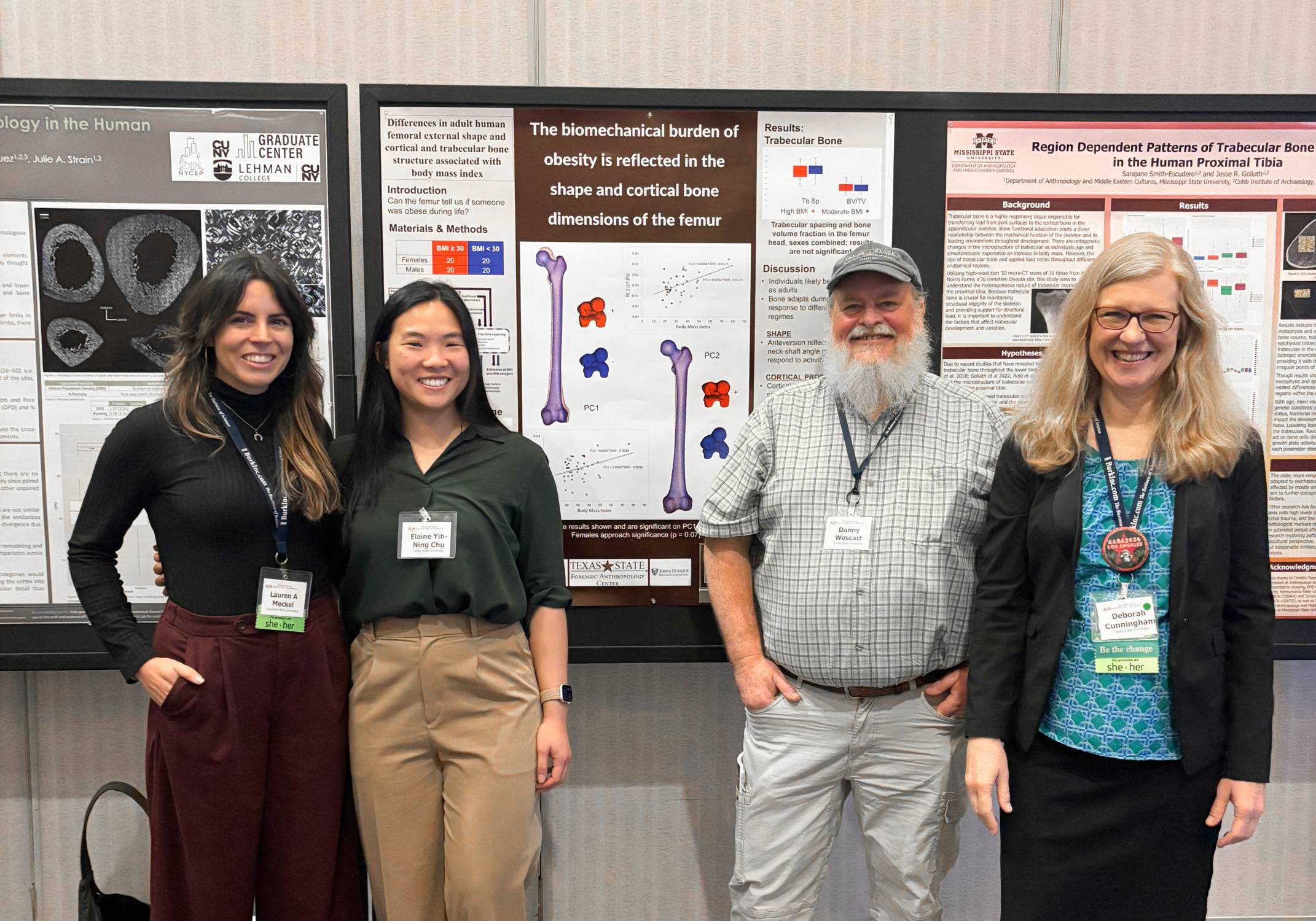 a group of researchers pose in front of a presentation poster