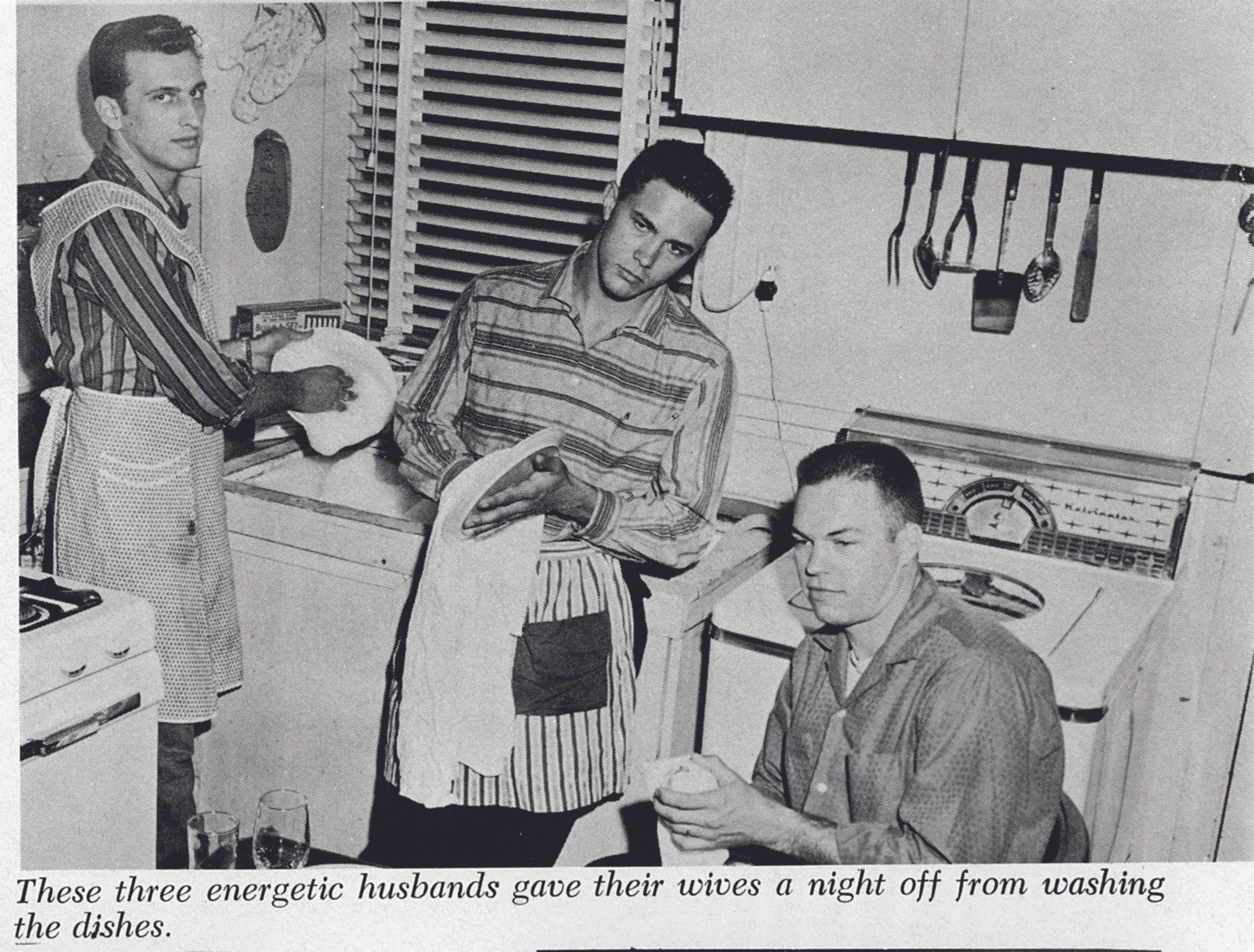 A clipping from the 1959 Pedagog. A trio of men stand in a small kitchen, having formed a small assembly line to wash and dry the dishes. The first man on the left gazes directly at the camera as he scrubs, wearing an apron. Next in line another young man in an apron leans forlornly against the counter as he dries a dish, and seated next to him a final young man dries another dish. None look terribly pleased about the situation. A caption beneath the yearbook reads 'These three energetic husbands gave their wives a night off from washing the dishes.'